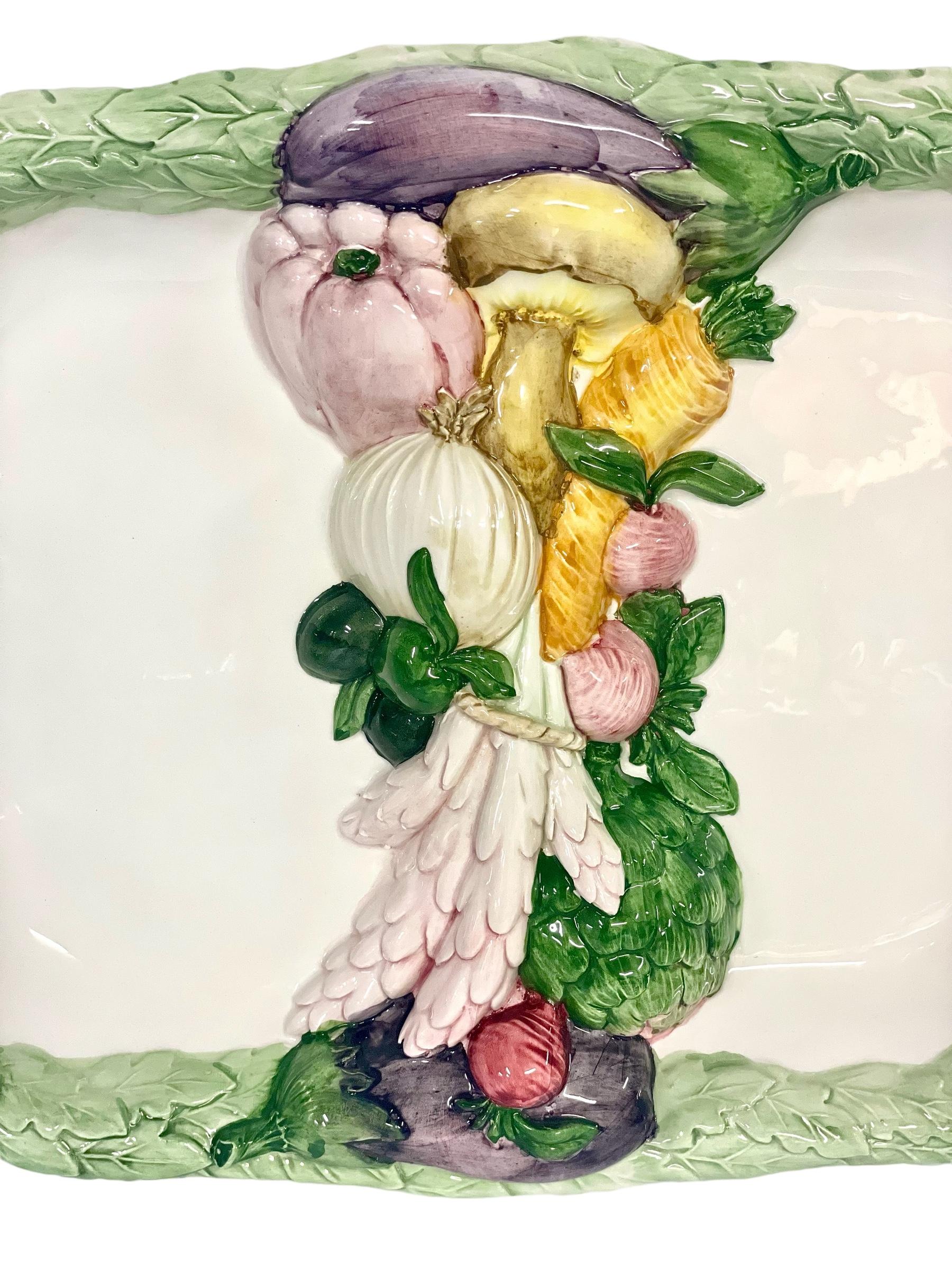 An attractive and unusual vintage serving platter, embellished with a central divider of beautifully crafted and hand-painted garden vegetables. A raised, embossed and painted green foliage border forms the rim of this elongated hexagonal plate,