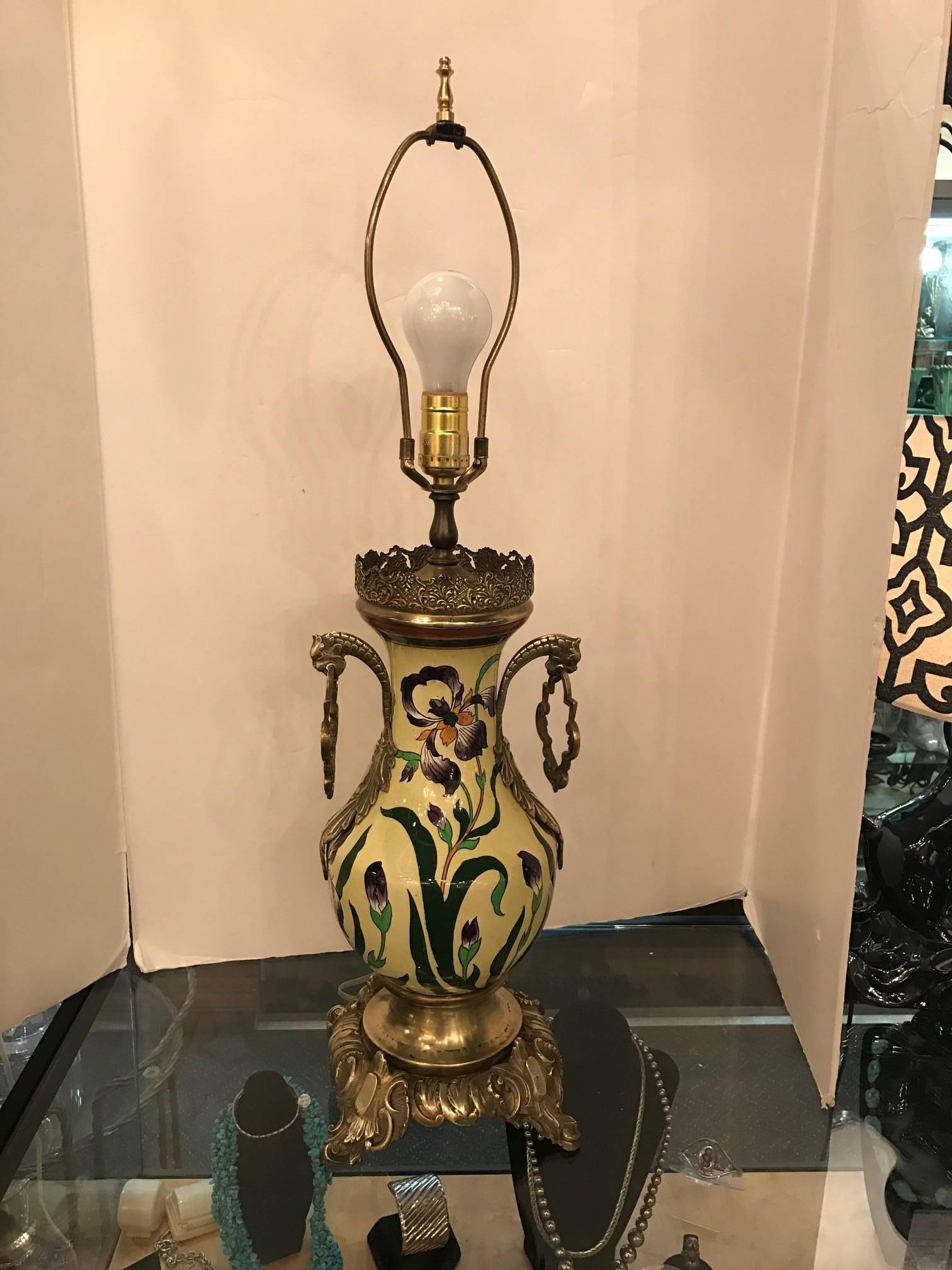 Vibrante urna de loza y bronce del siglo XIX pintada a mano y ahora electrificada. Fondo amarillo laberíntico con motivos de lirios y hojas pintados a mano. La pantalla básica tiene fines fotográficos y no se incluye con la lámpara. La altura total