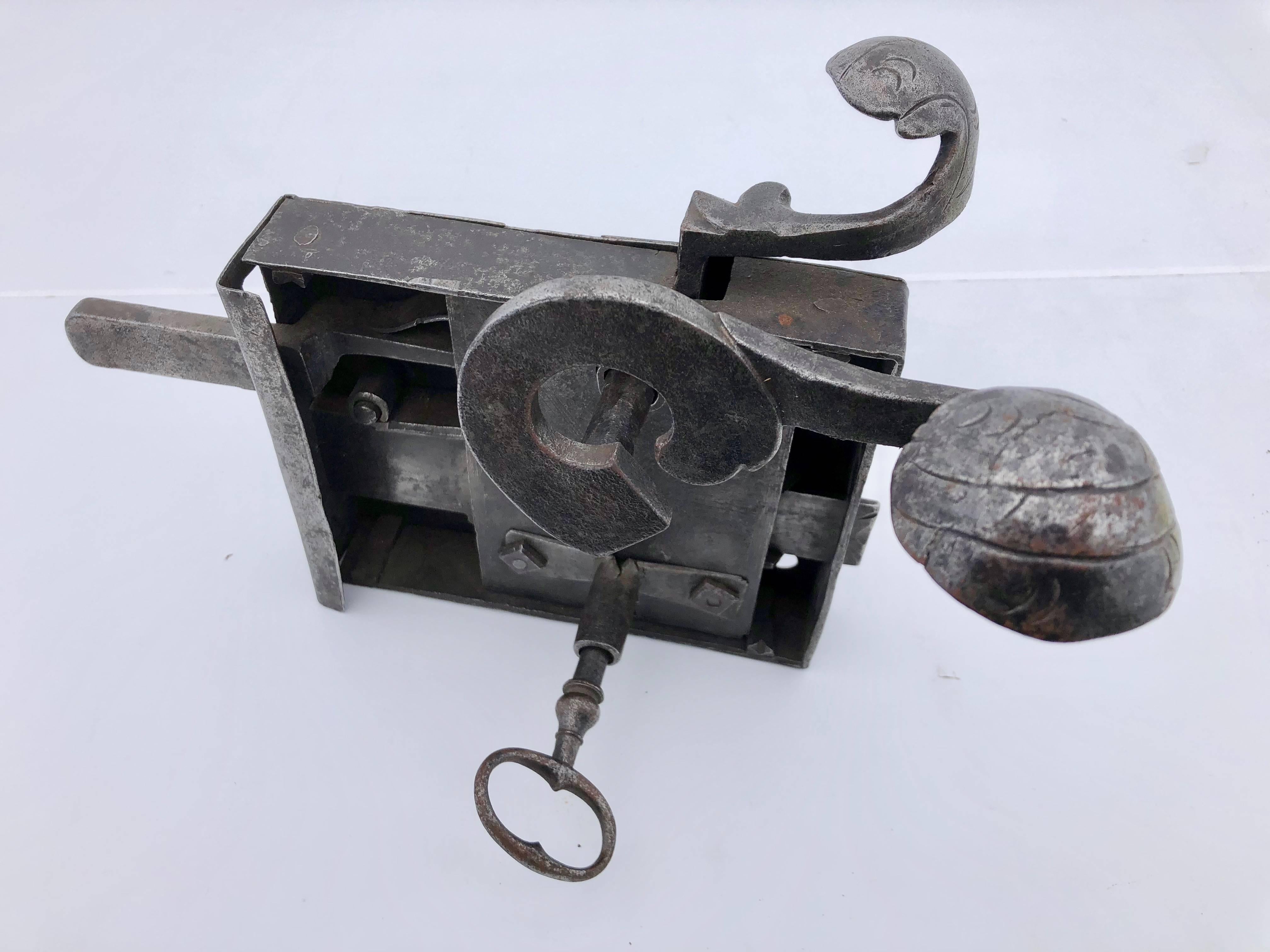 This Louis XVI French hand-wrought lock is absolutely gorgeous. It comes with it's own forged key and has a box shape frame with a deadbolt and a latch that work from both the front and the back. The front has a small lever which operates the latch