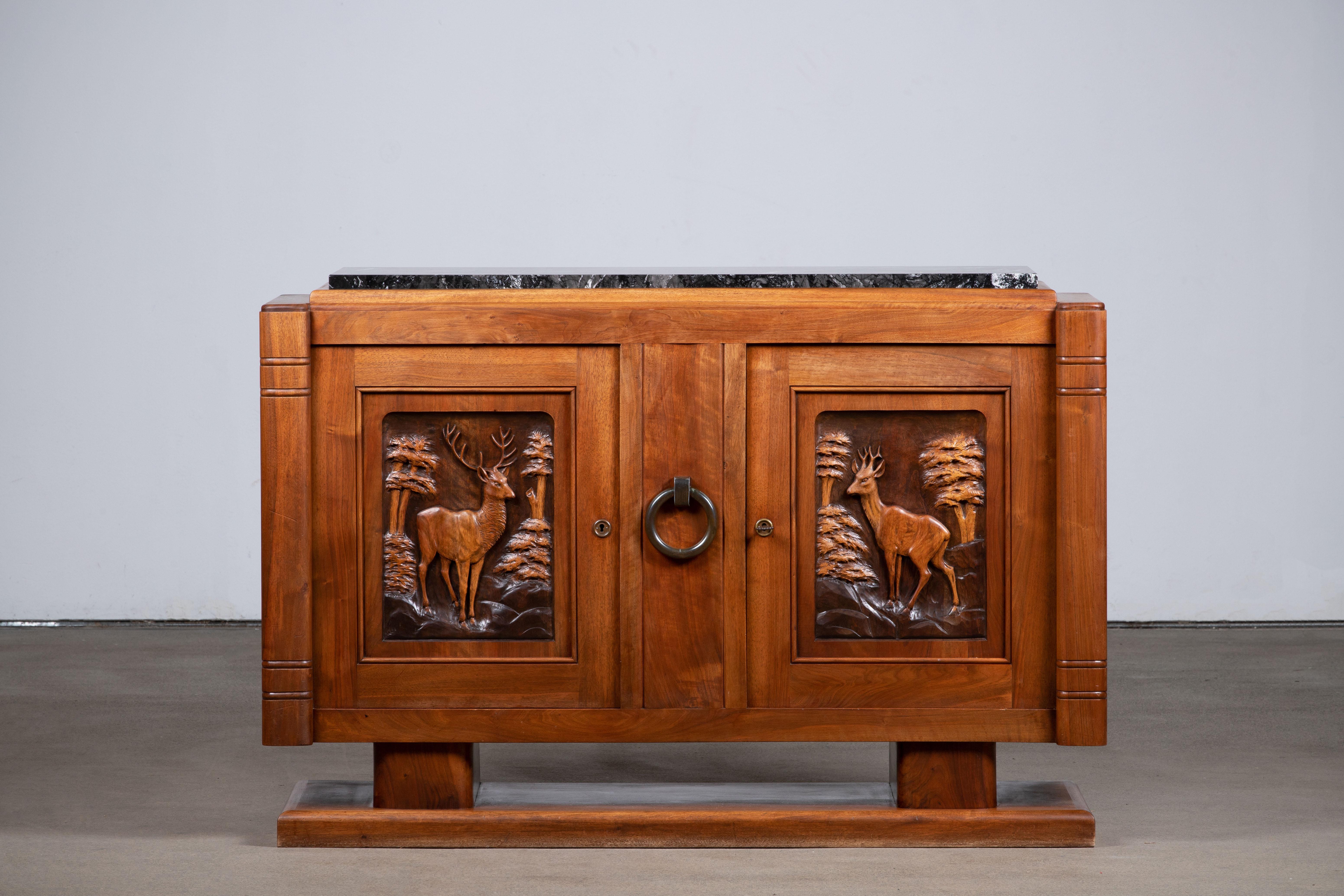 A large handcarved sideboard / credenza, France, c1940s.
Consists of 4 central drawer and two storage compartments. 
Inlaid wood center shelves, brass detailing and handcarved design doors make this piece really stand out.
The sideboard is in
