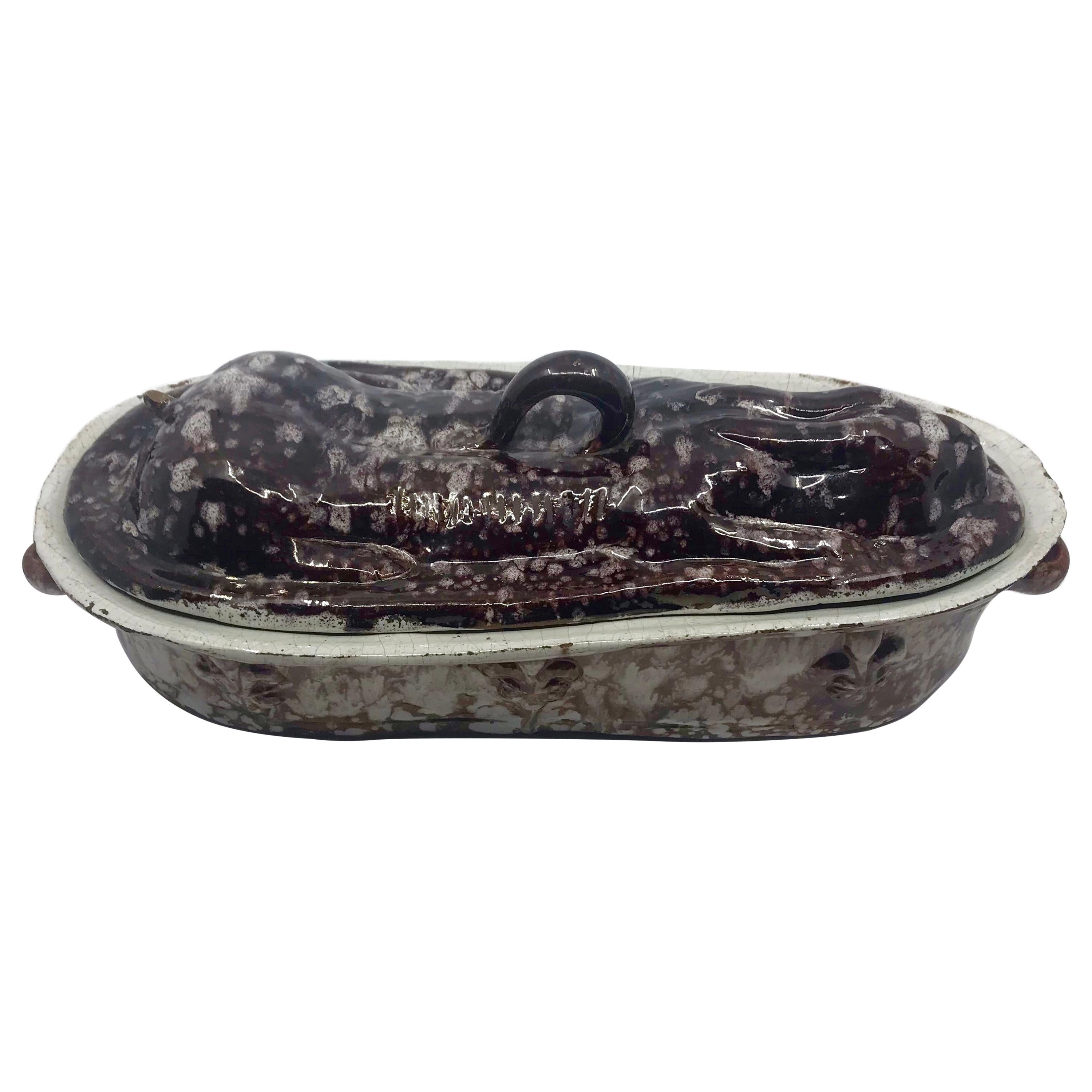 French rabbit tureen. Large glazed terracotta hare or rabbit tureen in mottled eggplant tones with hand-molded base with six raised Fleur de Lis and ribbon handles with molded lid fashioned in the form of a recumbent hare or rabbit with handle,