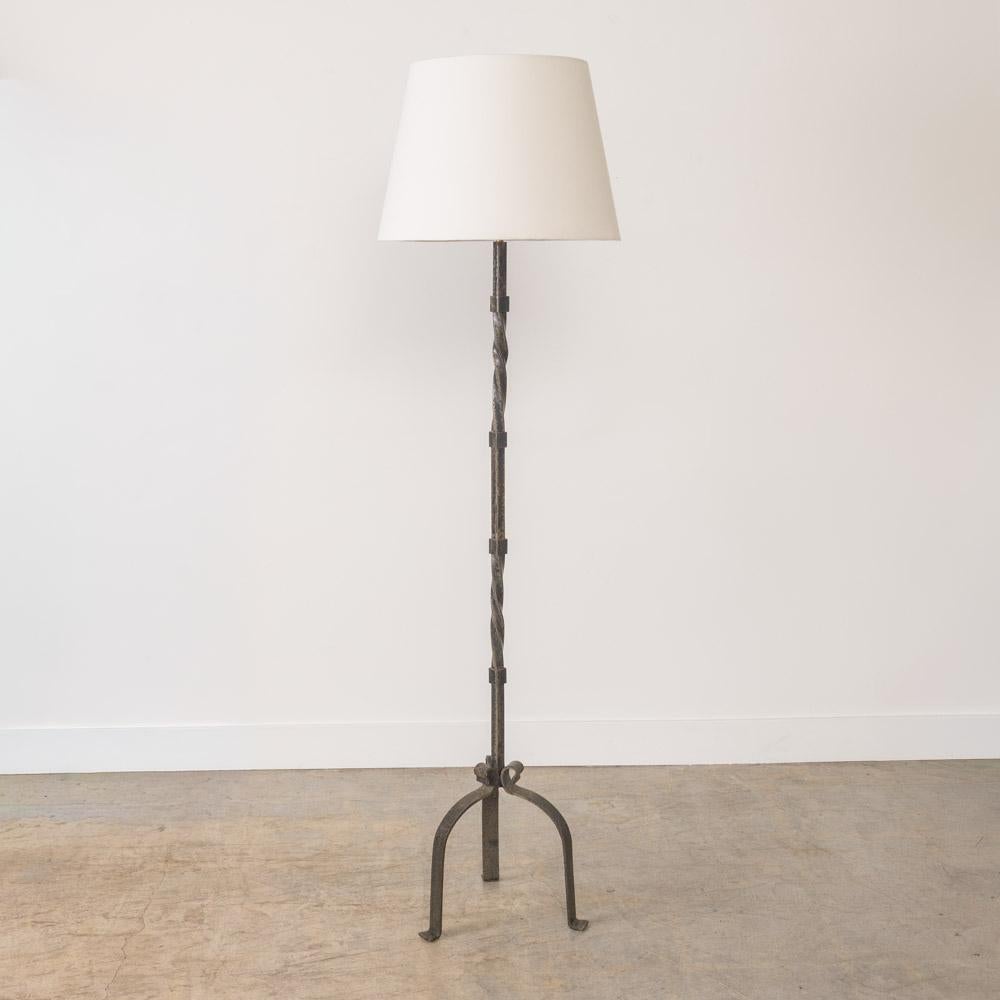 Lovely vintage wrought iron floor lamp from France, 1940s. Twisted iron stem with three curved iron legs. New linen tapered shade and newly re-wired. Unique and striking piece. Takes one E26 base bulb, 60 W or higher using LED.


