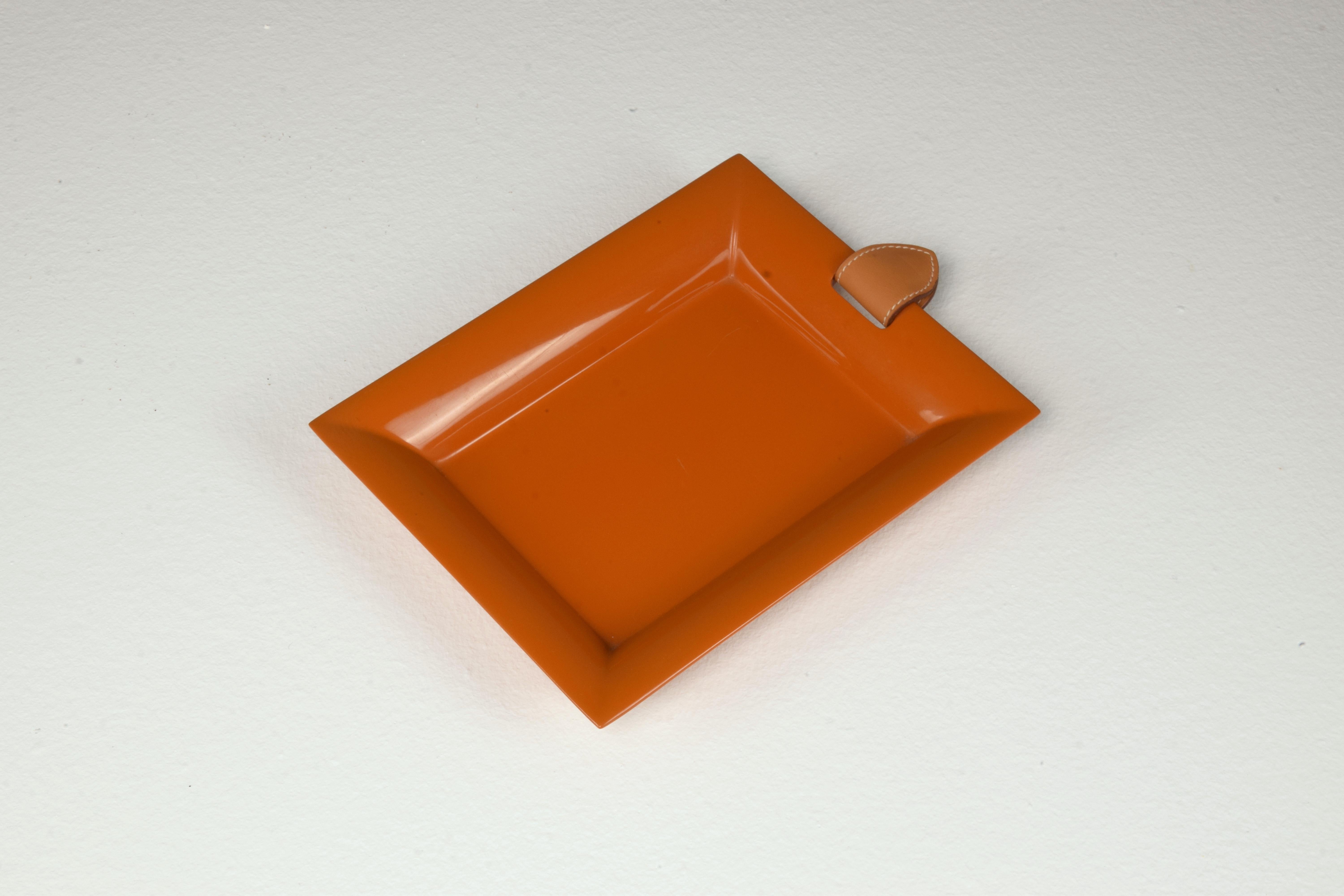 Rectangular vide poche or trinket tray by Hermes in hand-lacquered wood sheathed in a smooth bull calf with a magnetic seel in smooth bull calf stitched saddle. 
Lacquered in the joyful, rich iconic Hermes orange. 
Shiny lacquer set on top and