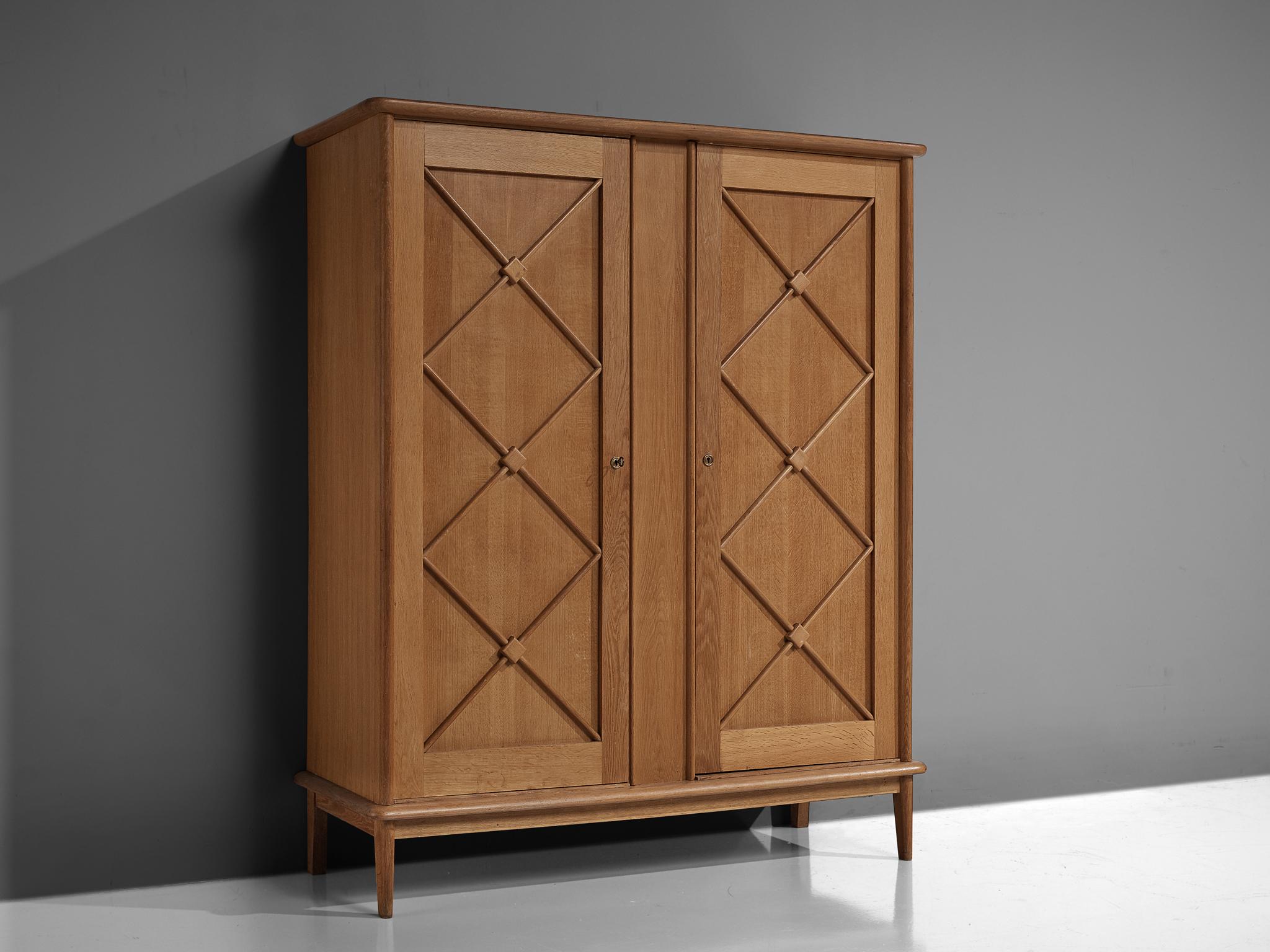 Cabinet, oak, France, 1960s

An elegant case piece in oak that features geometric details in the doors. The high board is lifted from the ground by slim, conical legs that give the solid looking body a more airy appearance. The cabinet offers
