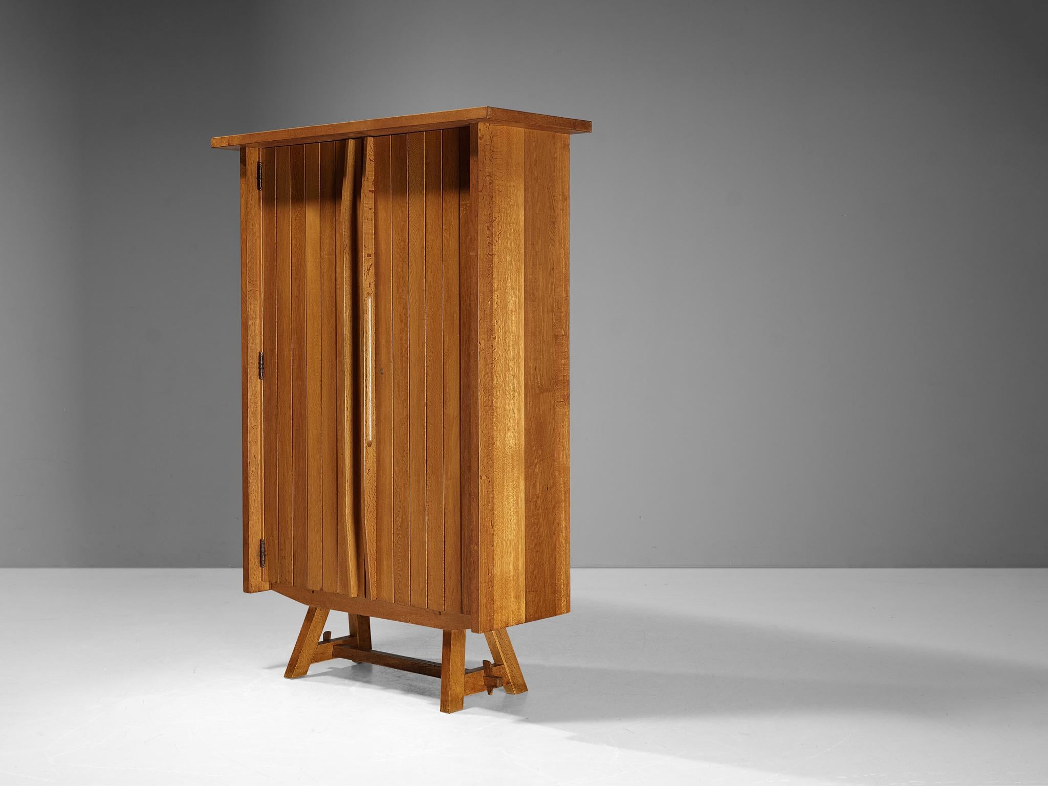 Wardrobe, oak, France, 1960s

A beautiful French tall cabinet made in expressive oak and displaying a stunning design. This elegant armoire has a considerable size which provides great storage space. The door panels are composed of carved vertical