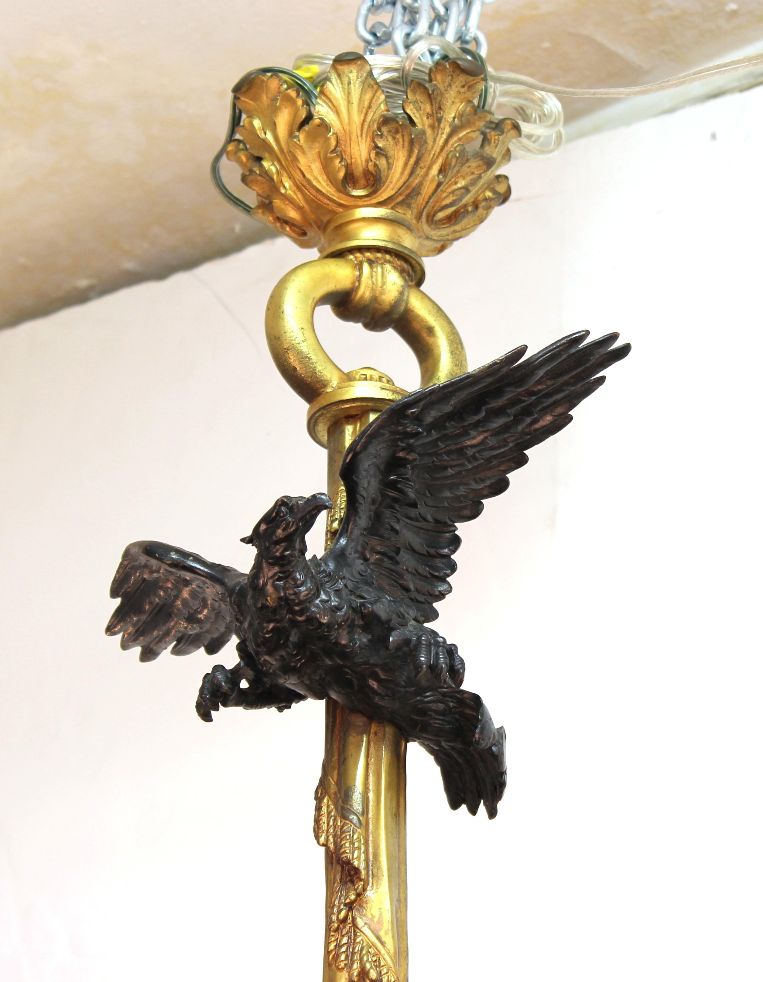 French 19th century Historicist bronze chandelier with an elaborately detailed flying eagle on the upper part and a putti hanging on to a flower basket out of which the arms of the chandelier emerge. The piece has been rewired and is in great