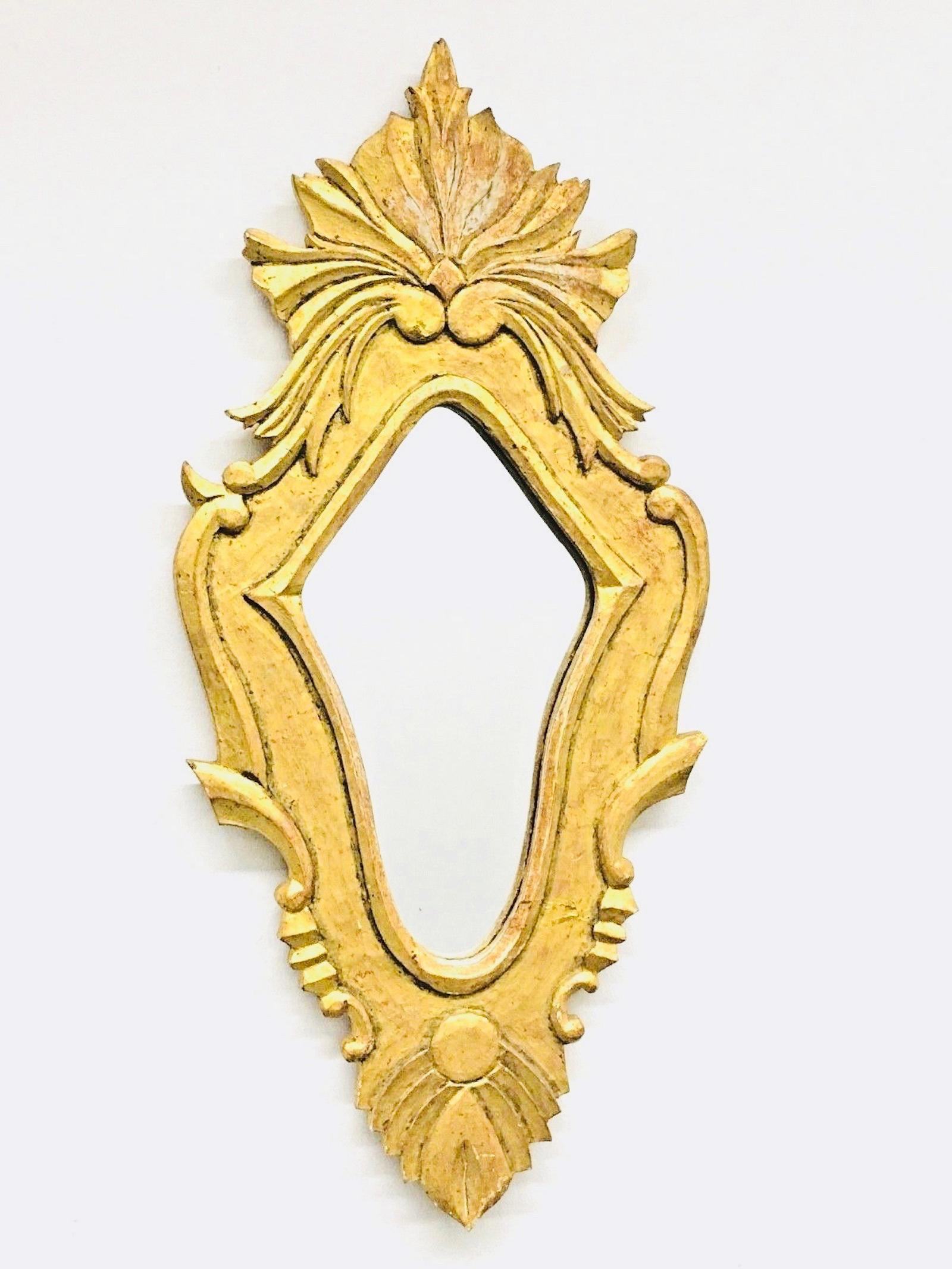 Atemberaubender geschnitzter Spiegel im Hollywood-Regency-Stil. Der Rahmen aus vergoldetem Holz umgibt einen Glasspiegel. Hergestellt in Frankreich in den 1960er Jahren. Schöner Spiegel für jeden Raum.