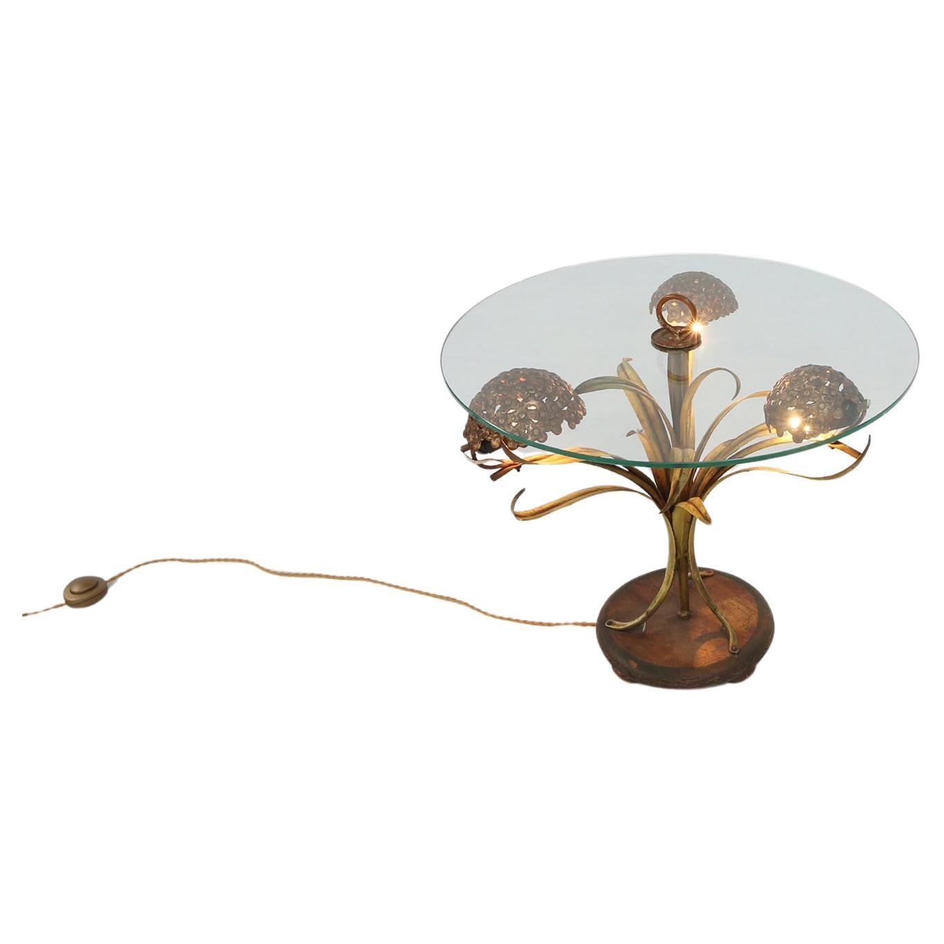France / 1950 / coffee table / metal and glass / mid-century / vintage / design

A unique and stylish coffee table with lighting in brass flowers and leafs, made in France ca. 1950. The table has a round glass top with brass ring-shaped handle.