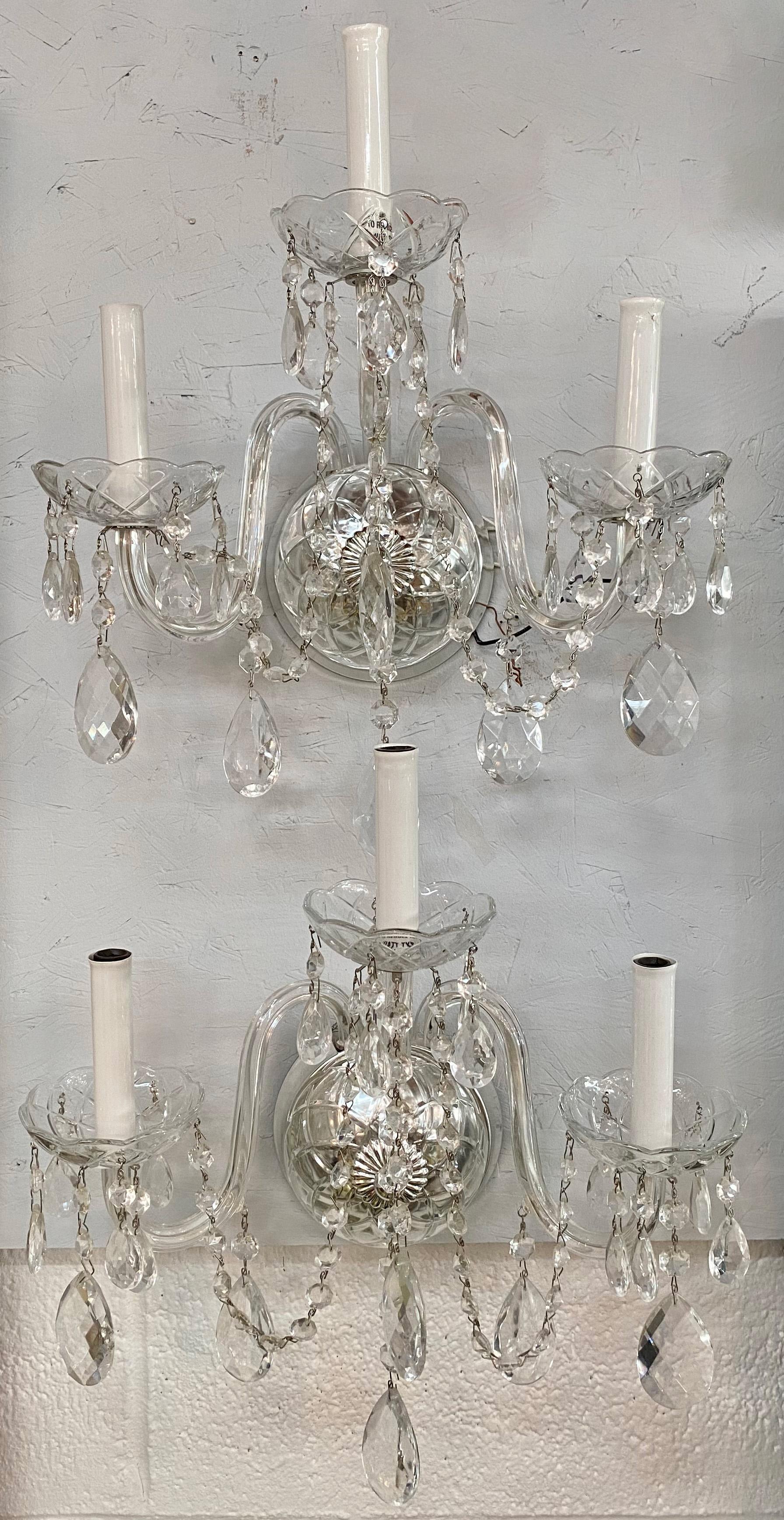  A remarkable pair of French Hollywood Regency style crystal wall sconces. These exquisite sconces are a tribute to timeless elegance and style. 
Crafted with meticulous attention to detail, each sconce features three gracefully curving arms, their