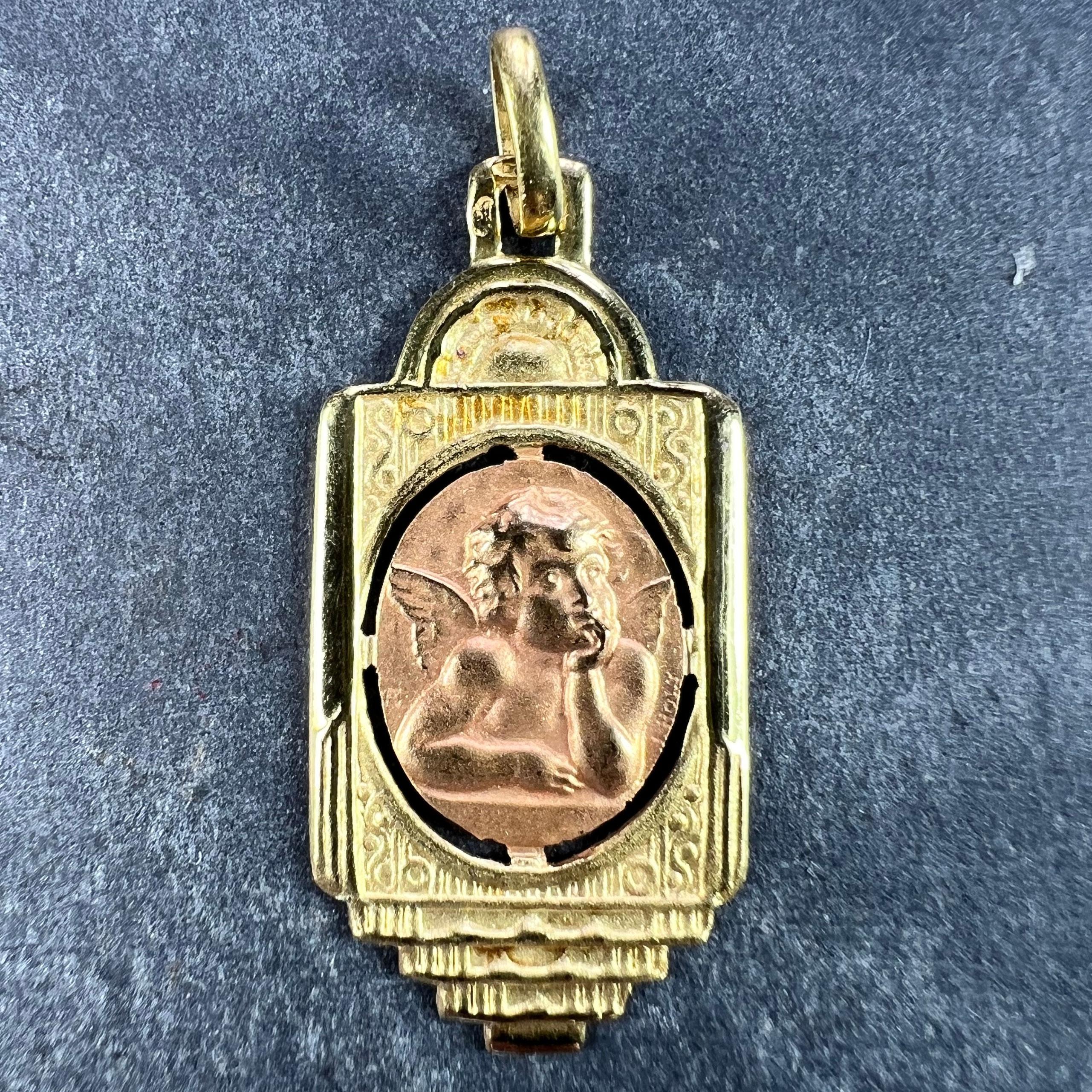 Pendentif de charme français en or jaune 18 carats (18K) conçu comme une médaille ronde représentant l'angelot de Raphael dans un cartouche ovale en or rose. Signé Holt. Estampillé de la marque de l'aigle pour l'or 18 carats et de fabrication