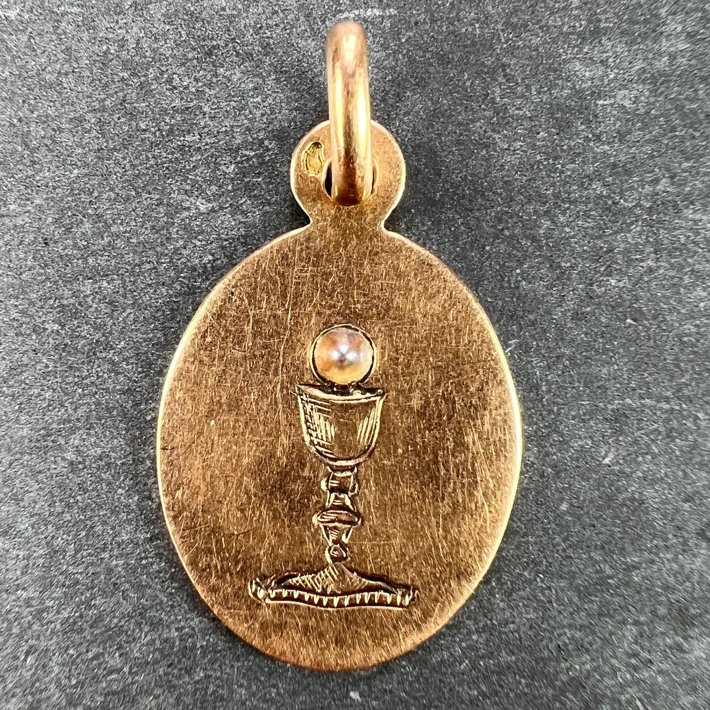A French 18 karat (18K) rose gold charm pendant designed as an oval medal engraved with the Holy Chalice topped with a pearl. Engraved to the reverse with the monogram SL and the date 18 Mai 1905. Stamped with the eagle mark for 18 karat gold and