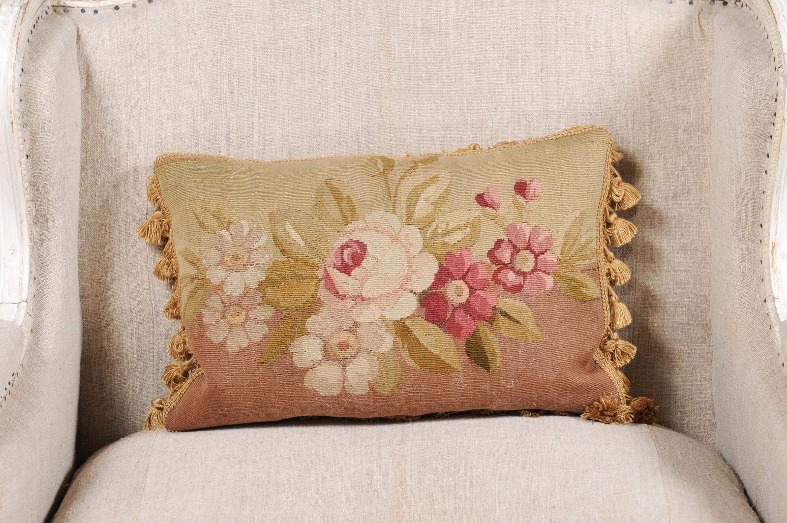 A French Aubusson tapestry pillow from the 19th century, with floral décor and tassels. Created during the 19th century in the Aubusson tapestry manufacture located in central France, this pillow features a delicate floral décor made of pink and
