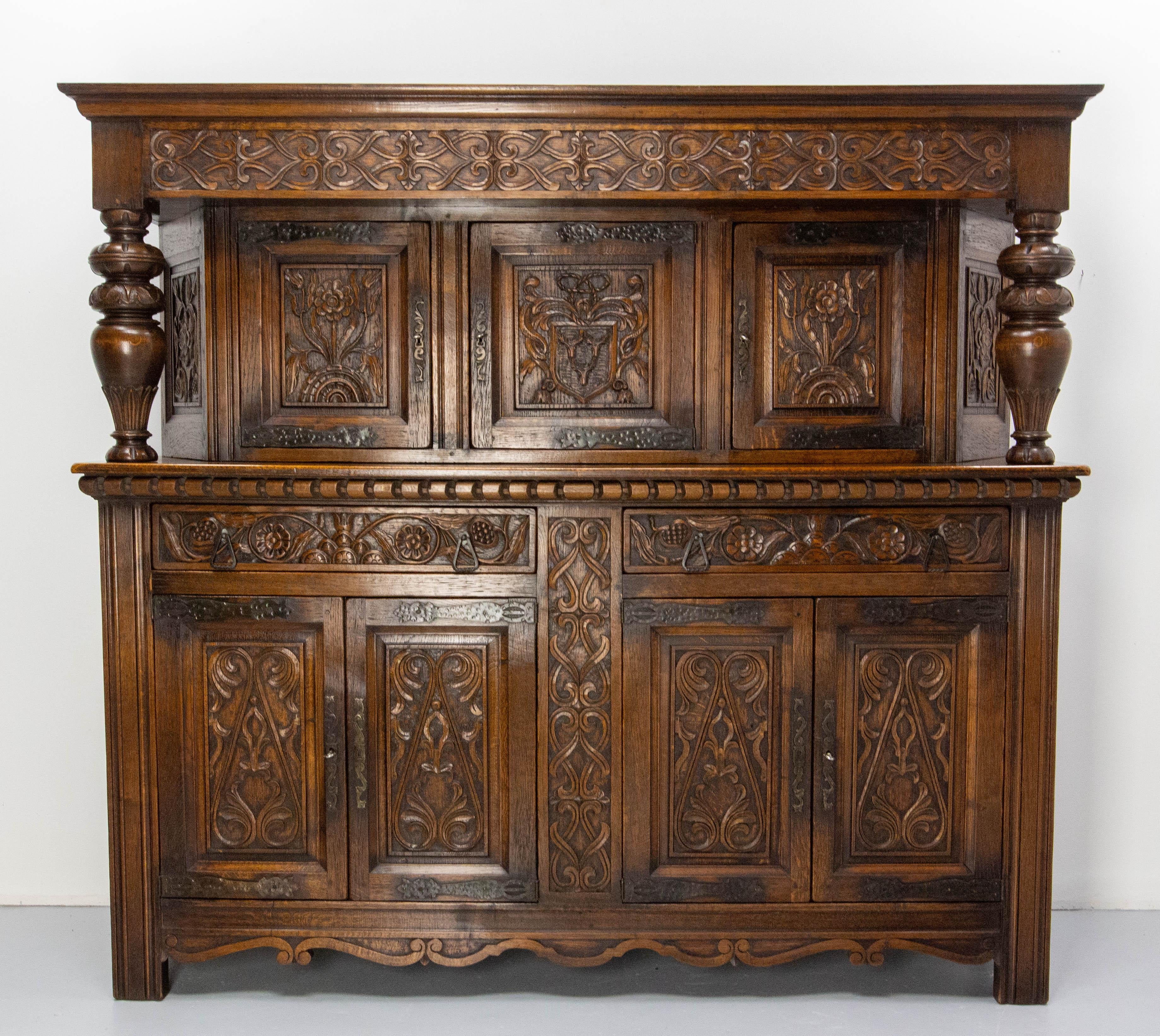 Spanish Renaissance style oak sideboard buffet.
This furniture was made in the 1960's and totally hand-carved. 
On the upper part the central panel represents a coat of arms with three deer heads. The rest of the furniture is decorated with