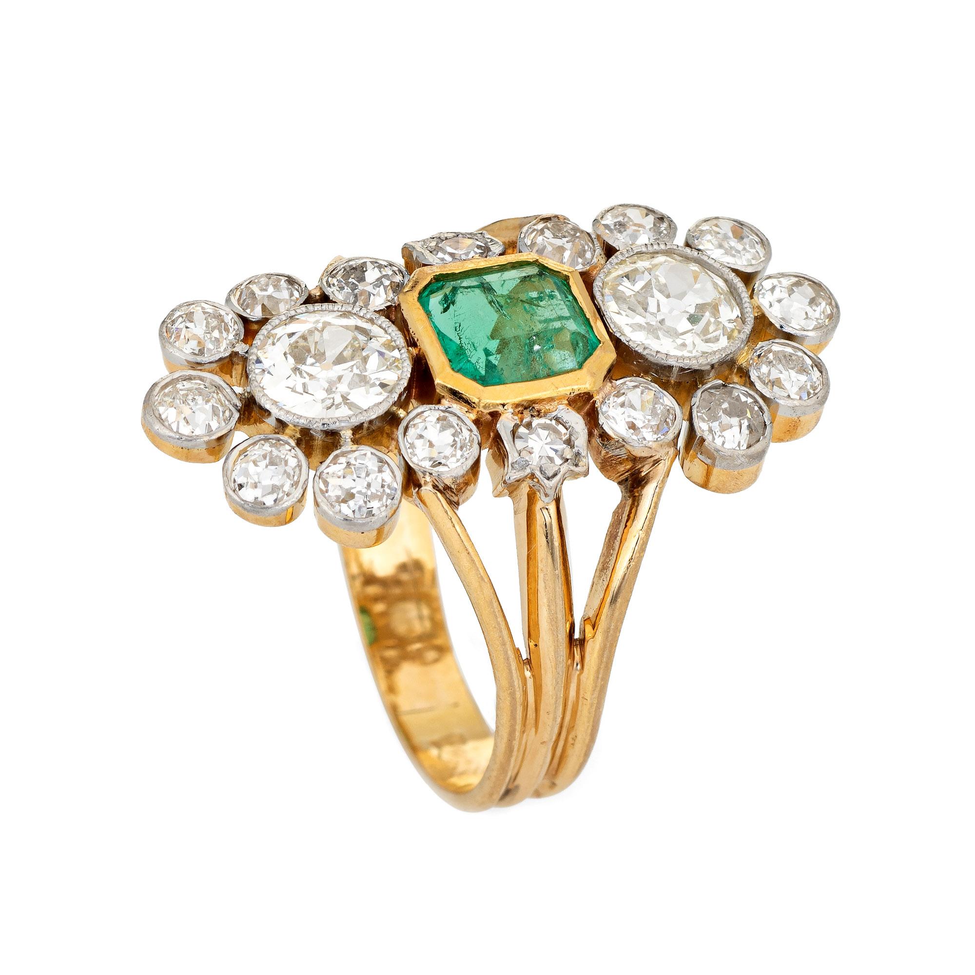 Stylish and finely detailed vintage early Art Deco diamond & emerald French import ring (circa 1910s to 1920s) crafted in platinum topped 18 karat yellow gold. 

The larger two old European cut diamonds are estimated at 0.55 carats each, flanked