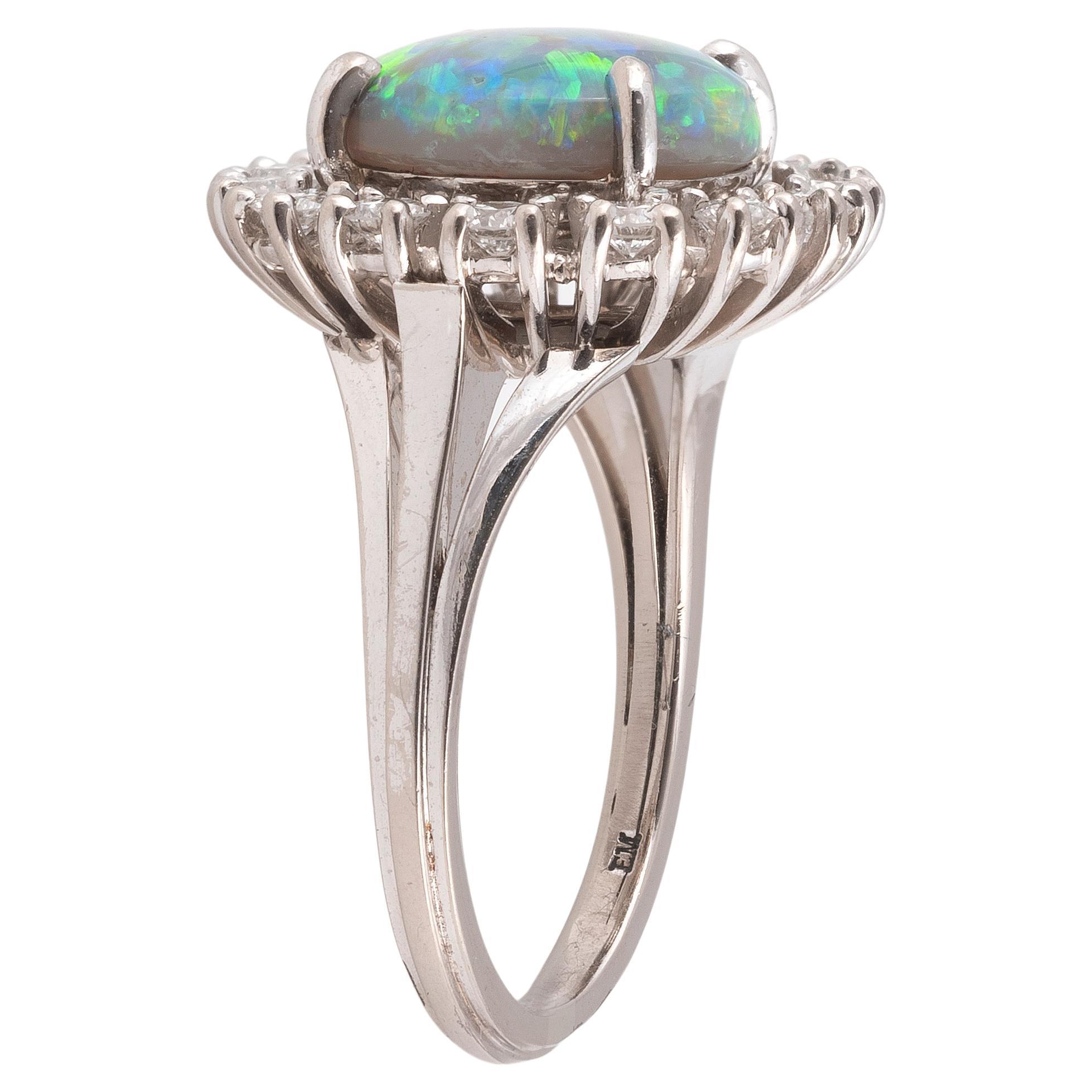 Im Mittelpunkt dieses atemberaubenden und eleganten Rings steht ein runder Cabochon-Harlekin-Opal, der von 14 runden Brillanten mit einem Gewicht von etwa 1,40 Karat umgeben ist. Der runde Cabochon-Opal misst 15 mm im Durchmesser und wiegt etwa 8
