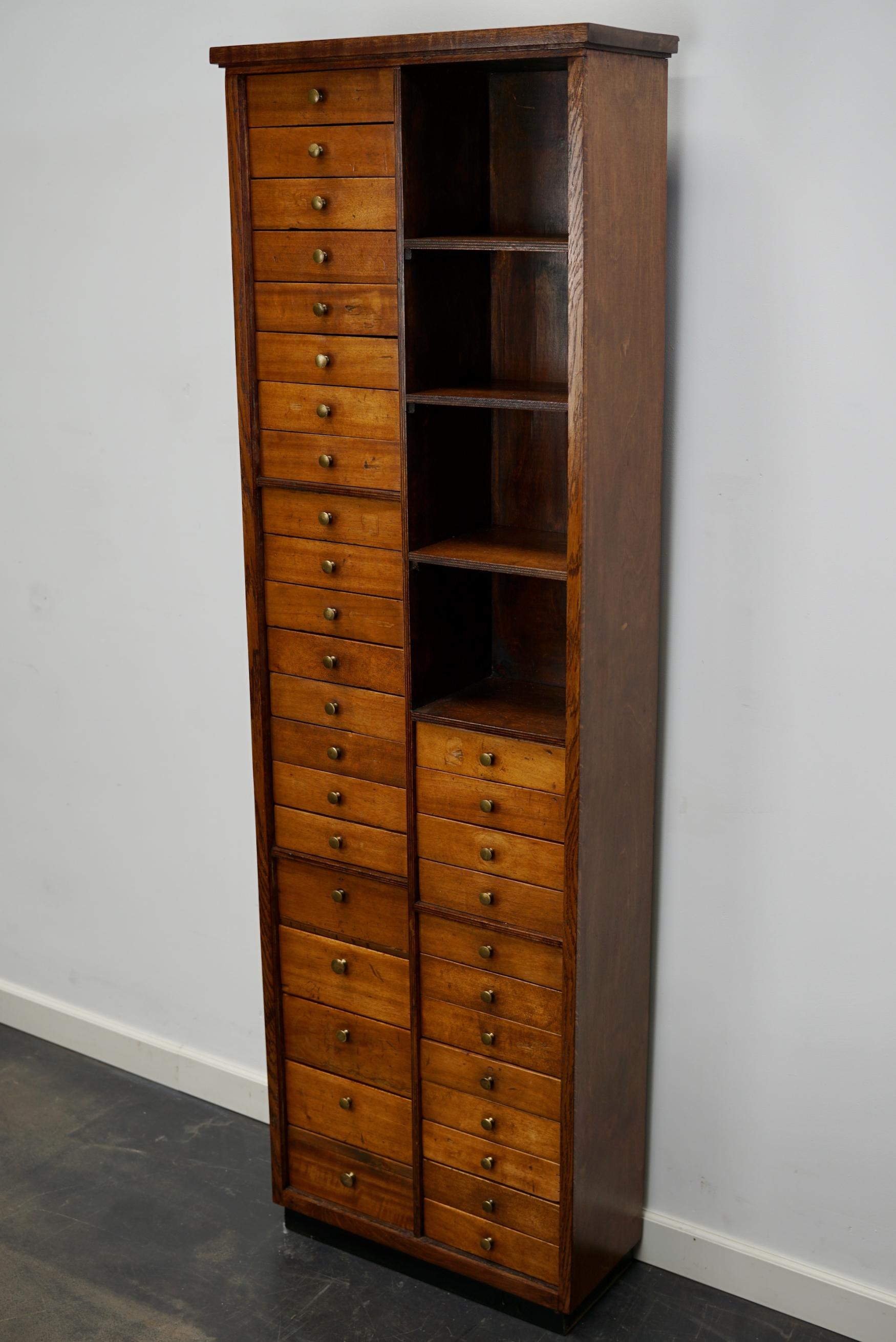 This beech cabinet with brass hardware was made in the mid 20th century in France and was used by a watchmaker. It is very well made and it remains in a good restored condition. The interior dimensions of the drawers are: D W H 14 x 17 x 4 & 8 cm.
