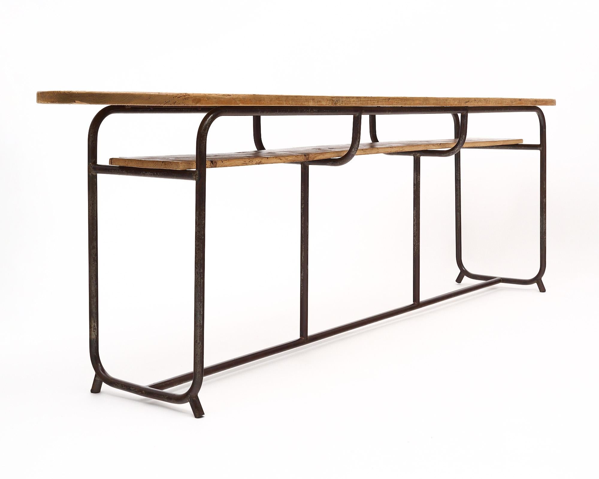 Console table from France in the industrial style. The structure is made of iron and features a wood top and wood shelf below for functionality.
