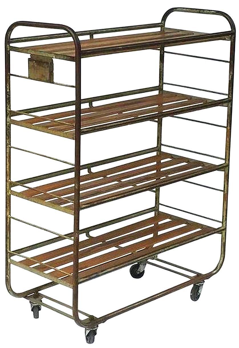 A fine French industrial rolling rack, featuring a tubular steel body with four-panelled wood shelves, set on four wheels, from a boot and shoe factory.

