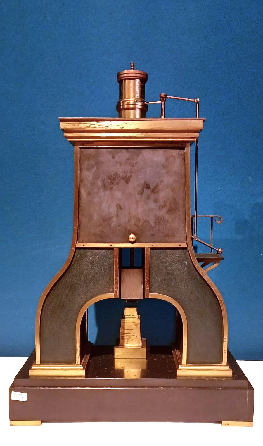 Horloge industrielle française à marteau à vapeur. 
Boîte en bronze bruni avec garnitures dorées représentant un marteau à vapeur industriel avec un cylindre à piston sur le dessus et un levier menant à une plate-forme sur le côté gauche, en bas