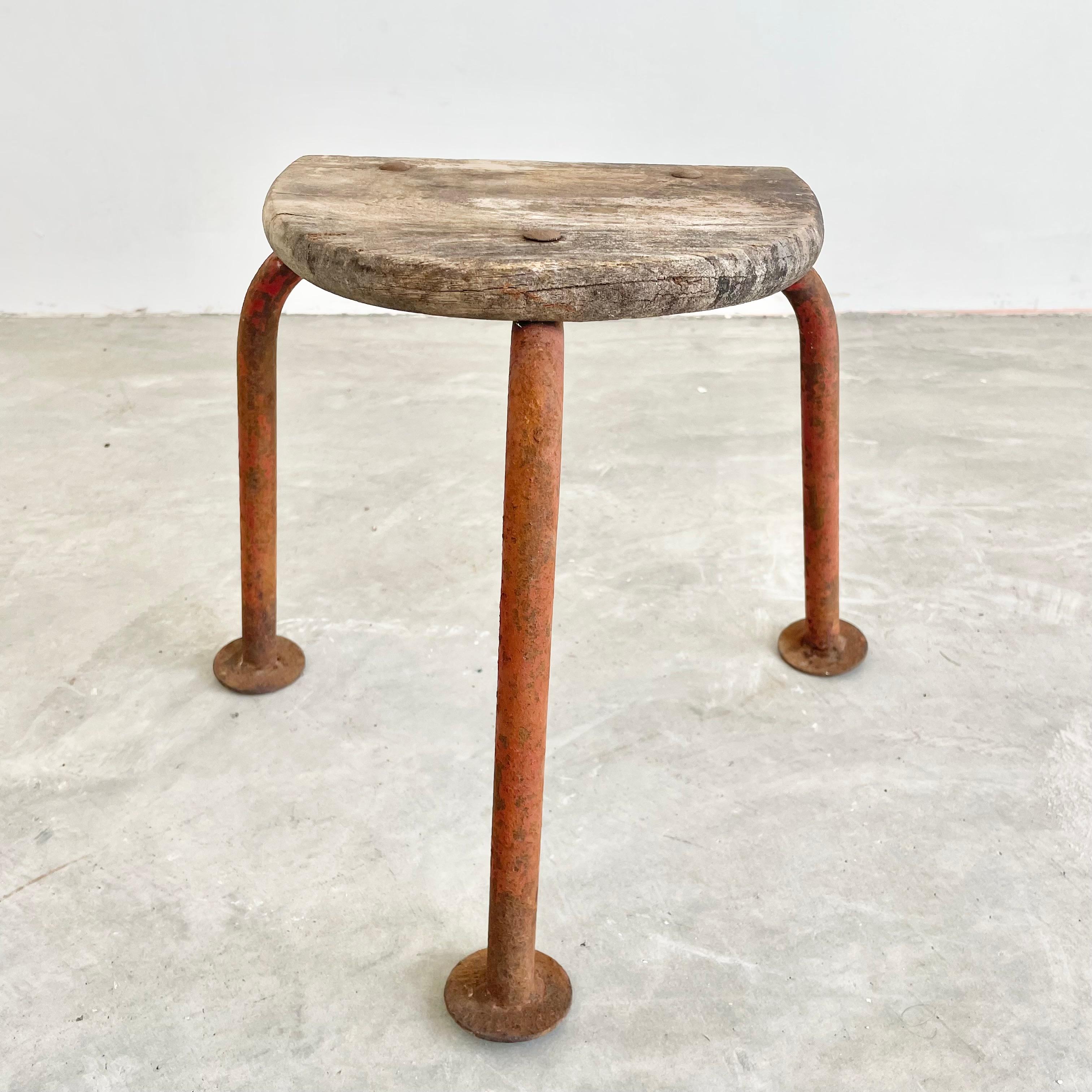 Tripod wooden stool, made in France, circa 1950s. Thick wood seat with three rounded metal legs. Great lines and shape. Petite stool with a lot of presence. Great vintage condition. Perfect for books or objects. Sturdy for sitting.
 
