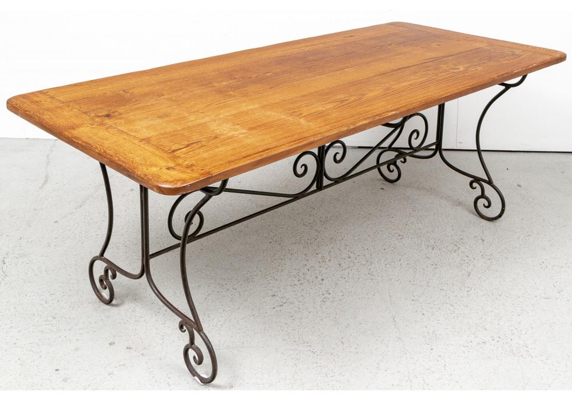 A handsome and solid feeling dining/work table with fine French styling. The top with bread board ends mounted on a fine iron base. The curved legs with scrolled feet and stretcher with scrolled center and ends. 
Measures: Length. 78 1/2
