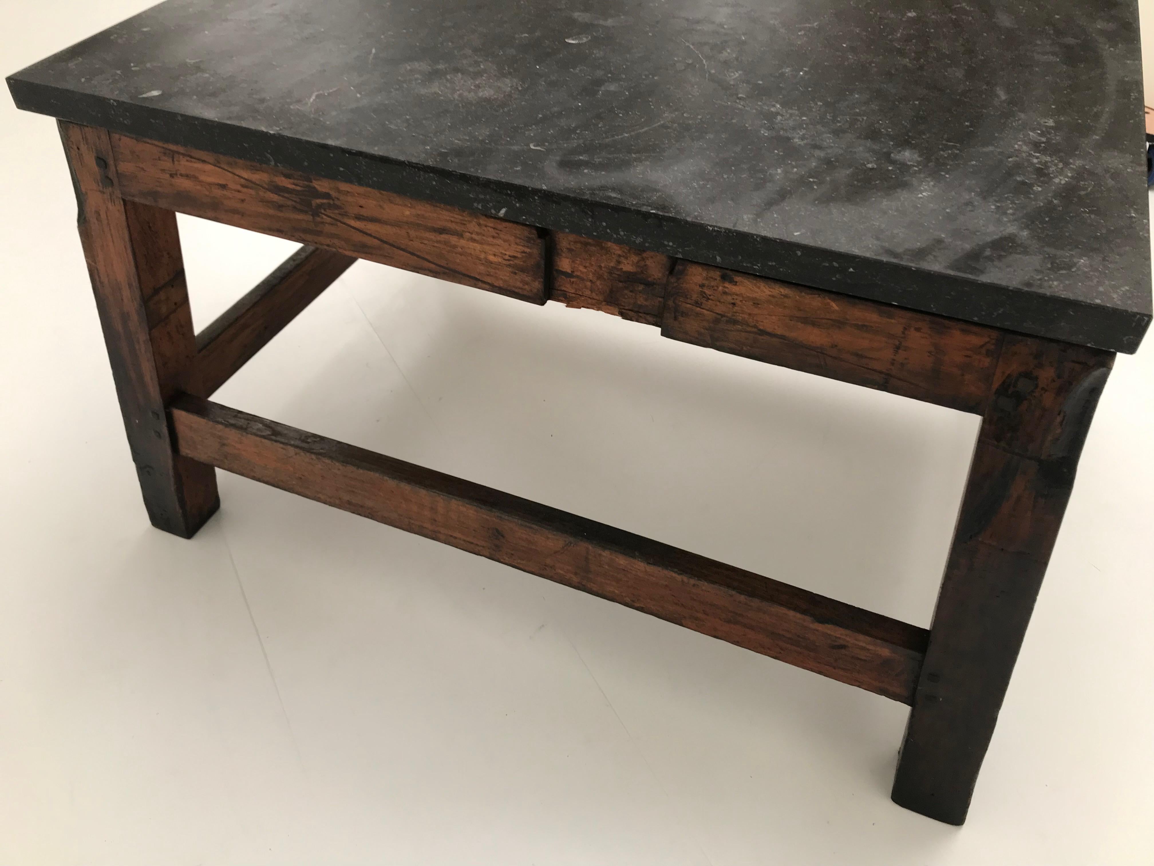 Eccezionale tavolo industriale con base in legno e piano in pietra blu di 4 cm di spessore,
un look potente e di grande effetto. Ideale per la cucina o il ristorante.