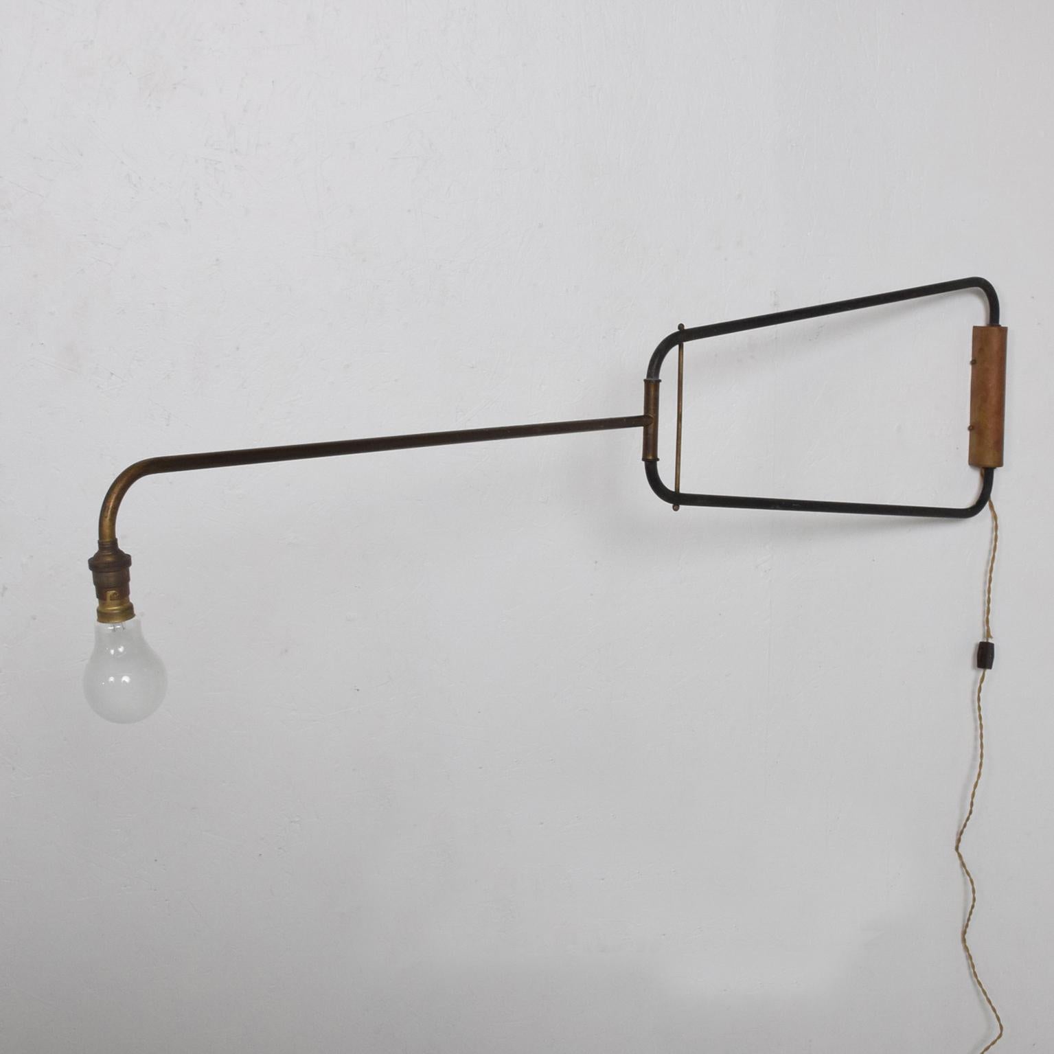 In the manner of Jean Prouvé a vintage industrial wall sconce, France, circa 1950s.

Simplicity in suspension. Minimalist design. Patinated brass. Bayonet bulb exposed. Dimensions: 52 1/4