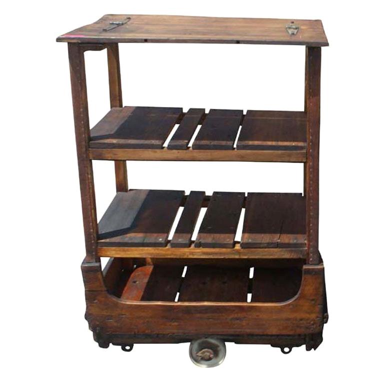 French Industrial cart from the early 20th century. Wooden frame and shelves with leather covered wooden supports and iron wheels.

 