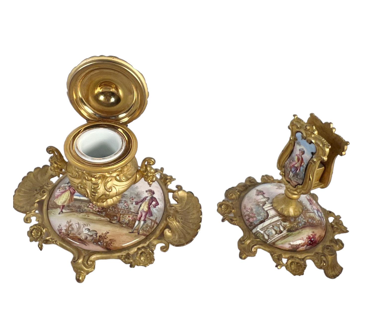 This exquisite French enamel and bronze inkwell and match holder set, adorned with hand-painted figures, is a stunning piece of functional art. Perfect for collectors or anyone looking to elevate their workspace with timeless sophistication. The