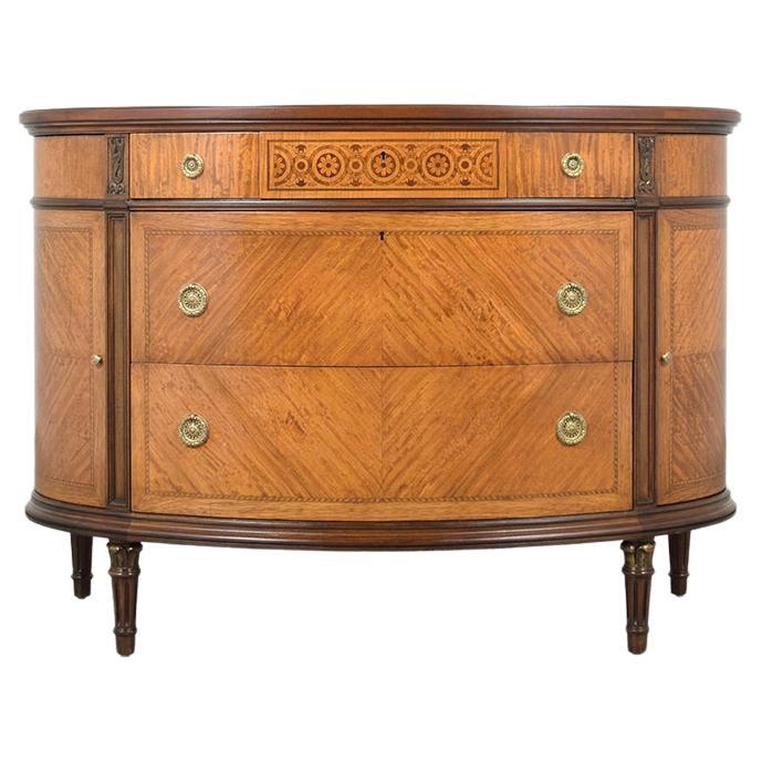 Embark on a journey to the past with our magnificent French Louis XVI commode from the 1940s, meticulously restored to its former glory by our skilled in-house artisans. This exquisite piece of history is handcrafted from solid wood, showcasing the