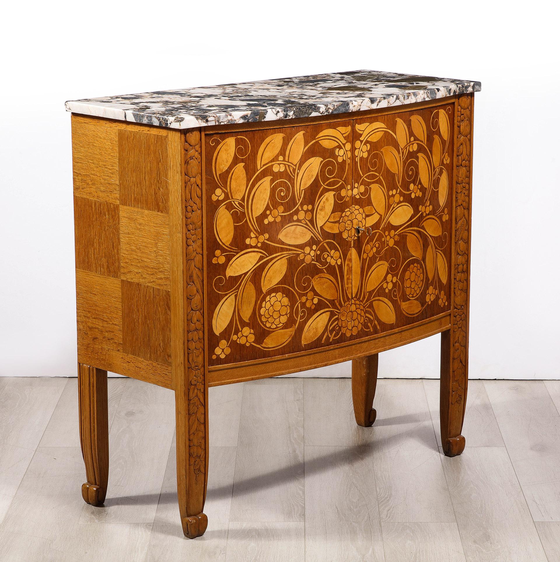 The variegated marble top supported by a richly carved oak case with two elegantly rendered sycamore marquetry in doors.

Reference: 