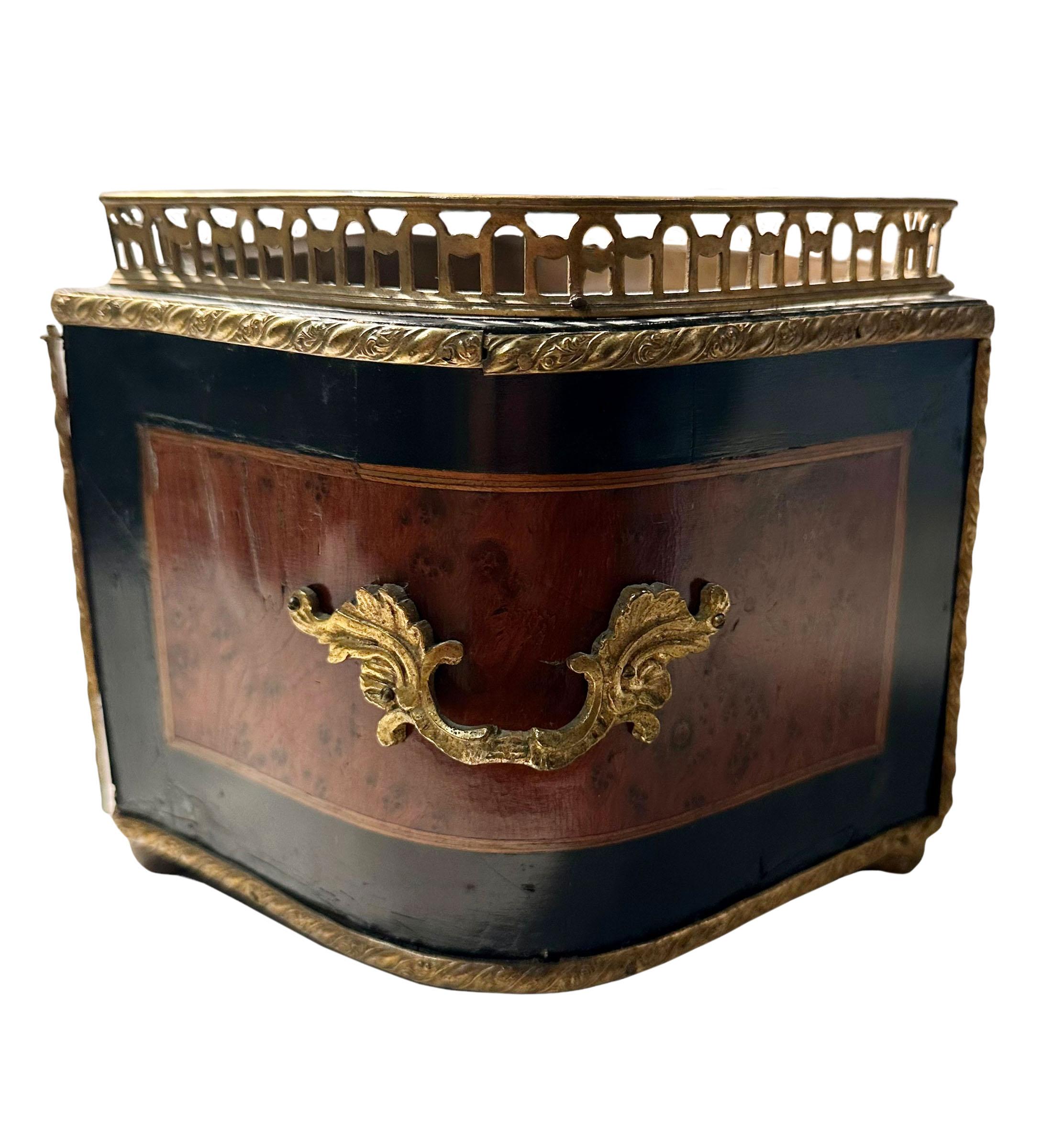 A French jardiniere inlaid with ebony and fruitwood with gilt bronze ormolu handles and feet. The planter has a very nice brass liner inside and is about five inches deep. 
