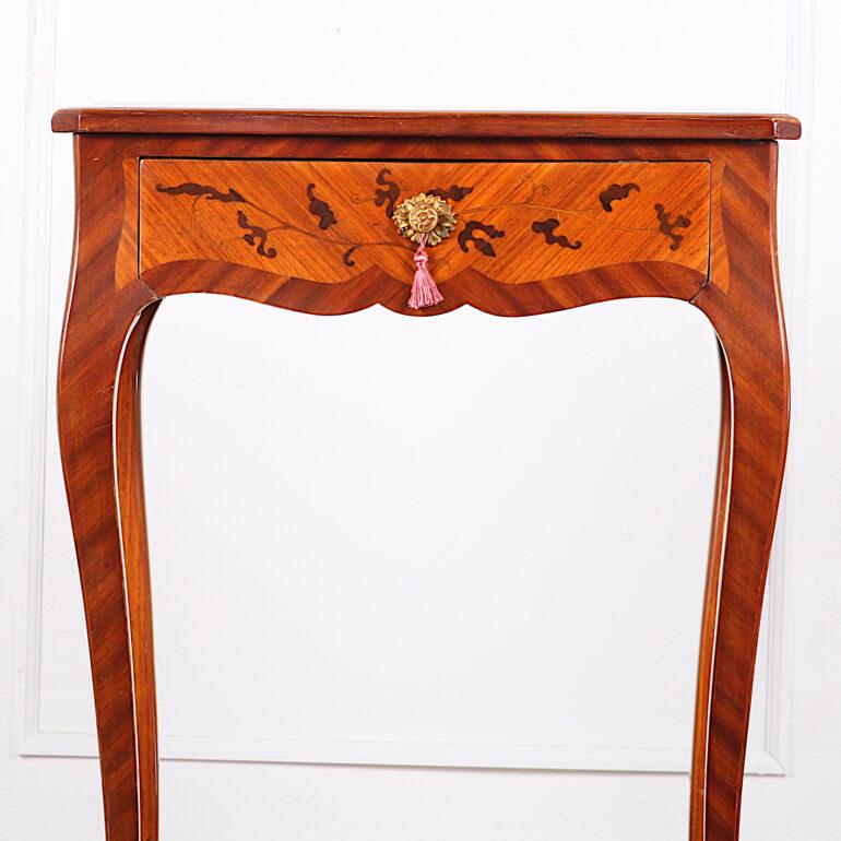 A vintage French-made Louis XV style serpentine-side table or stand in kingwood, the top and sides embellished with inlaid mahogany marquetry and having a single fitted drawer, the whole standing on elegant tapering cabriole legs with gilt bronze