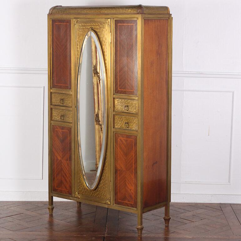 Very unusual small French brass-bound and inlaid mahogany cabinet or armoire, the door and drawer fronts with engine-turned brass finish, the door with its original oval beveled mirror. Likely originally fitted to a ship's or rail passenger's