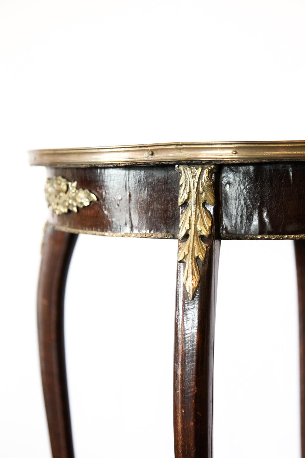 French inlaid marquetry shelf table, the cross banded top with inlaid flowers and foliate, surrounded with brass band; the apron, knees and feet with elaborate brass appliques, lower concave shaped shelf with inlaid stylized star.