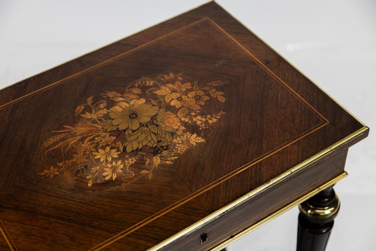 French inlaid rosewoodlift top side table, the top interior with ormolu acanthus leaf frame around distressed mirror, four interior compartments. The exterior top has floral inlays and a bookmatched rosewood top with boxwood double string inlay.