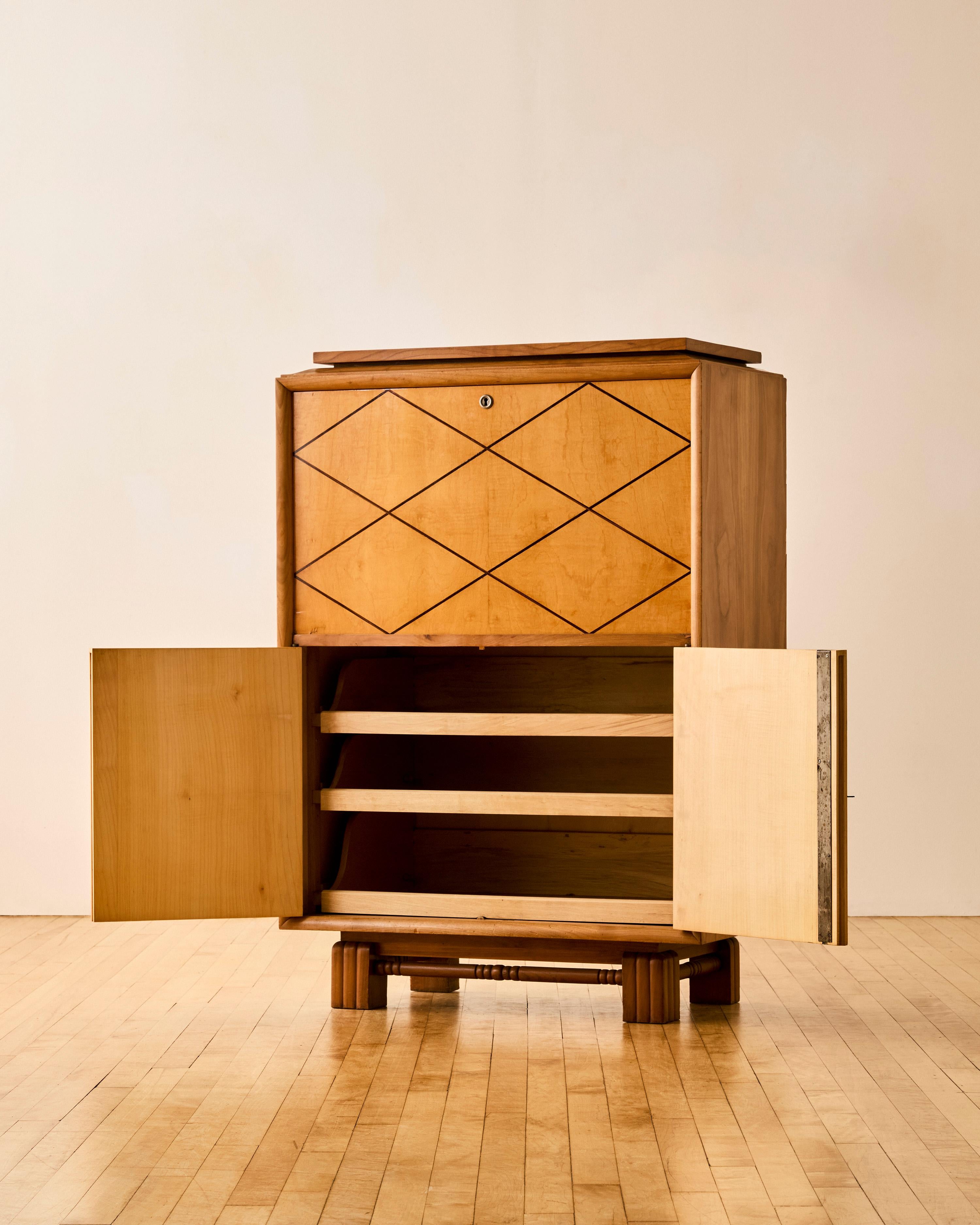 French inlaid sycamore bar cabinet with brass key hole detailing and a fall front opening to a mirrored shelf over two doors concealing pull our trays c. 1935. 