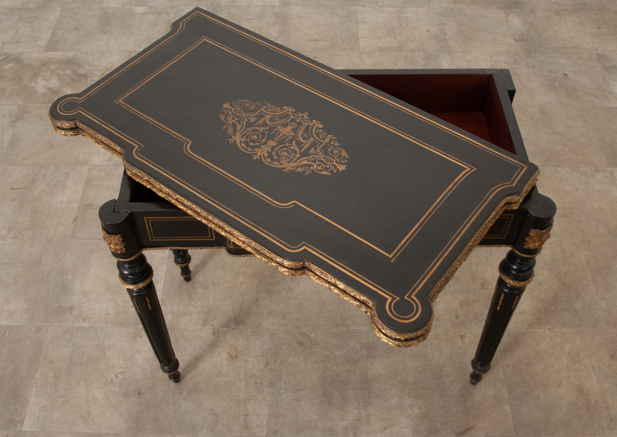 This Louis XVI Style ebonized game table / console is smart and sure to elevate your interior. As a console this table boosts a lot of characters. The center cartouche on the table's surface is full of intricate details surrounded by layers of brass