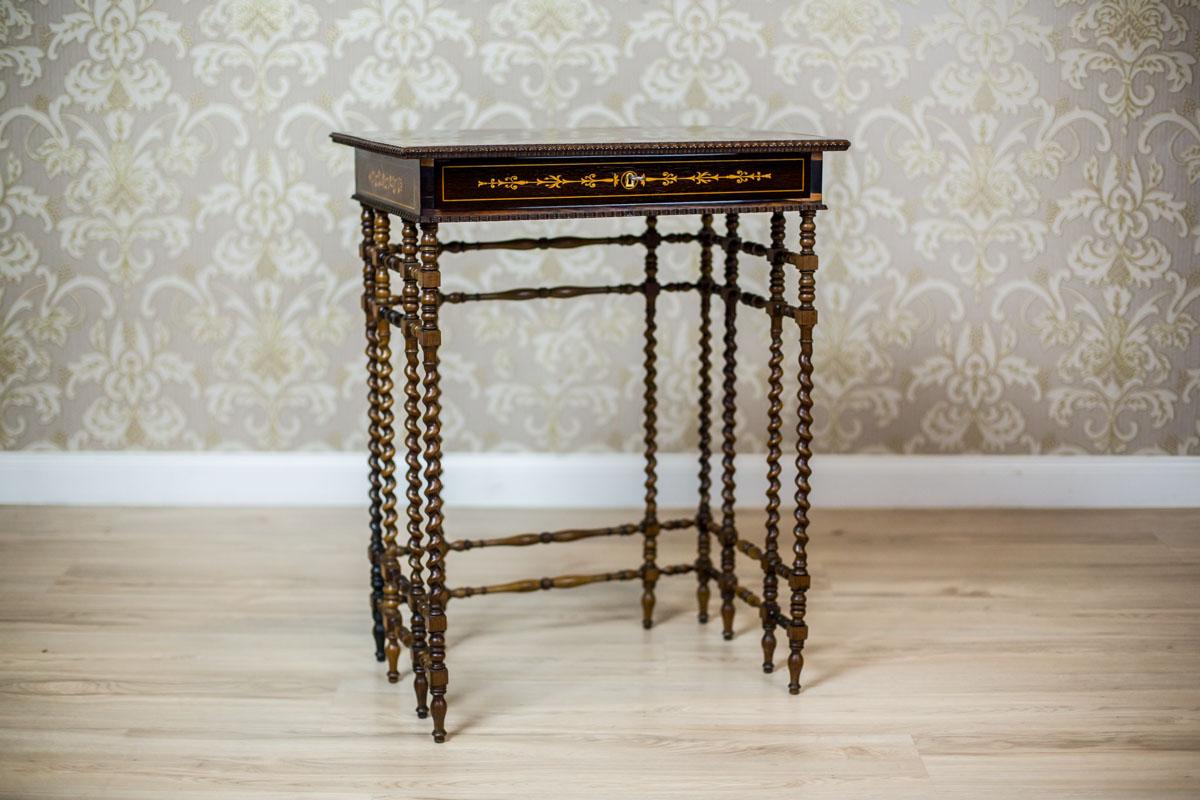 We present you a beautiful sewing table, dated the first half of the 19th century.
The rectangular apron is covered in rosewood veneer with beautiful intarsias. Under the top, there is a narrow drawer with a pincushion inside.
The whole is