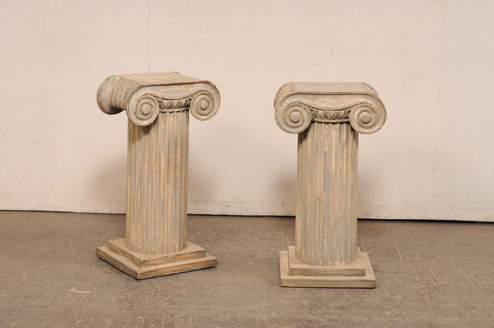 A French pair of custom painted column pedestal accent tables from the mid 20th century. These mid-century pedestals from France are each design in an ionic column style, with rounded and fluted bodies, and flattened tops more rectangular-in shape,