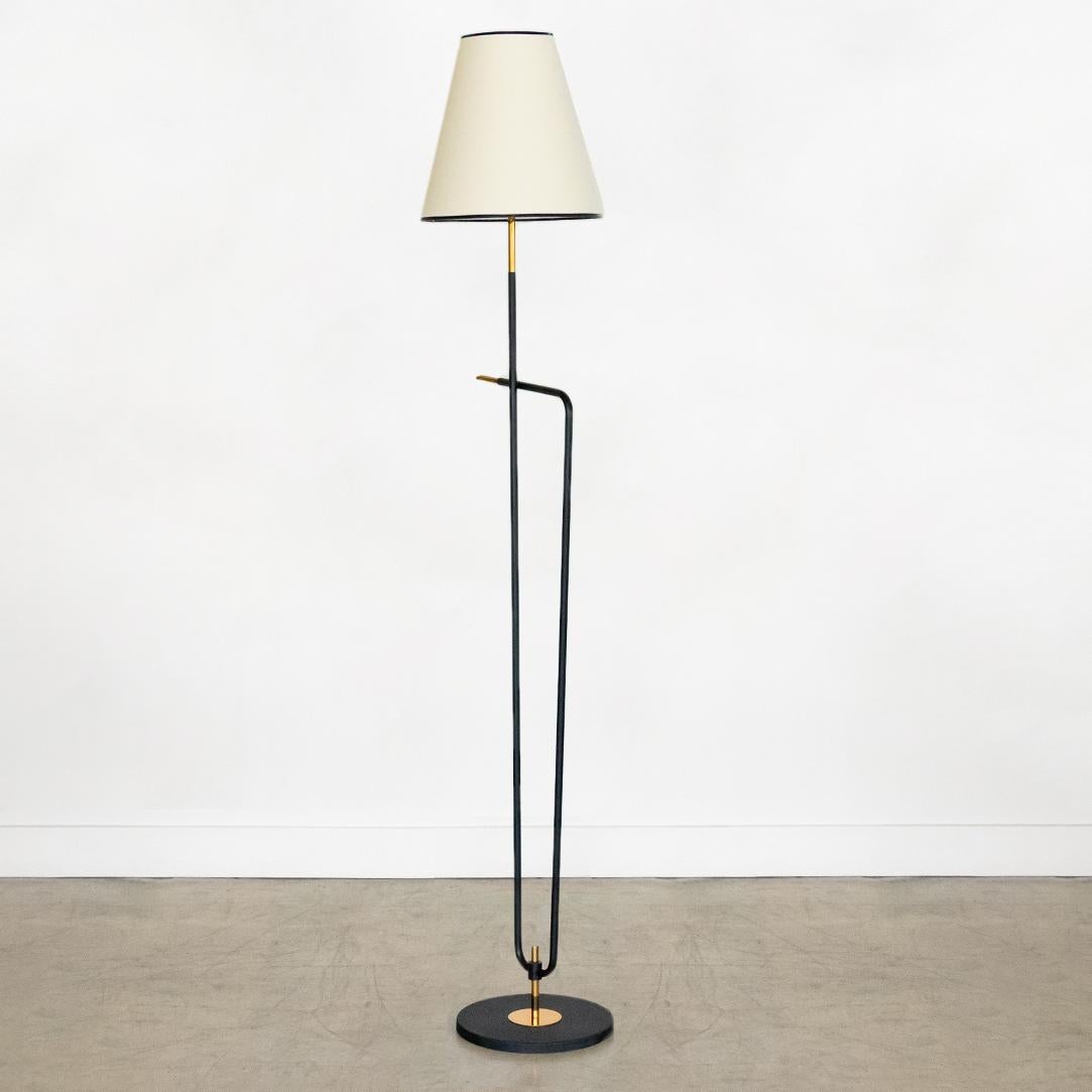 Black iron floor lamp with brass detailing from France, 1950's. Two black iron stems bend to create interesting angular form. Newly rewired and new paper shade with black trim. Original condition showing age and patina.