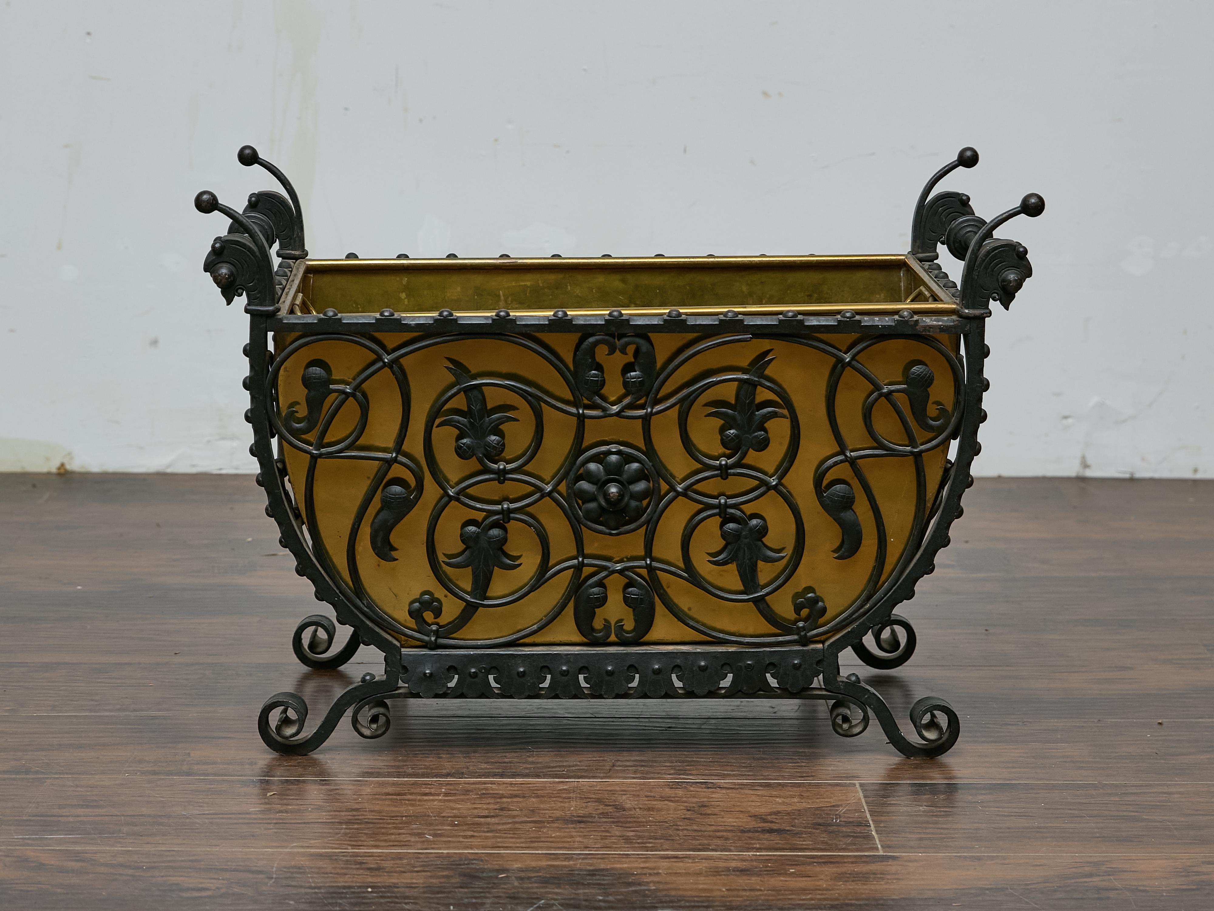 Un jardinière in ferro e ottone francese del XIX secolo, riccamente dettagliato, con una graziosa silhouette a forma di barca e una lavorazione del ferro a spirale densamente lavorata. I lati sono definiti da volute intrecciate, motivi a forma di