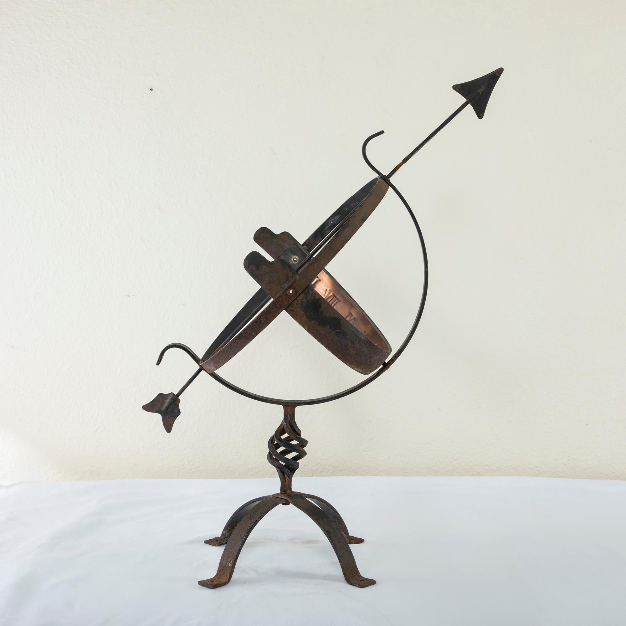 This large French armillary sphere and sundial is from the turn of the twentieth century and stands at 28.75 inches in height with a 15 inch diameter. It features an iron Stand with with a twisted wrought iron pillar. The sphere is fitted with an