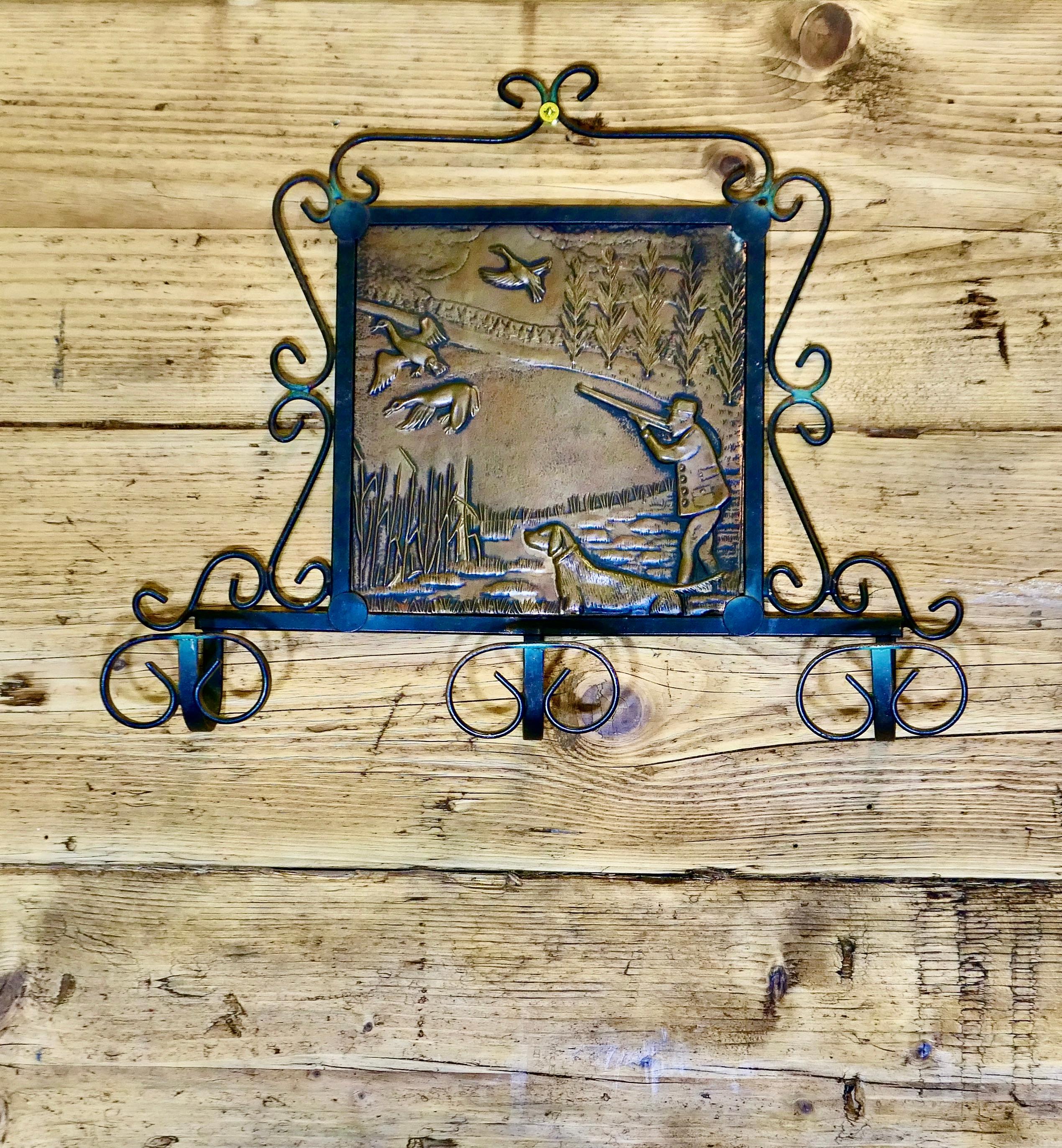 French Iron and Copper Coat Hooks on a Hunting Theme

This is an attractive wall hanging coat rack with 3 double coat hooks beneath at the centre it has a decorative beaten copper panel on a Hunting theme with a huntsman and his dog shooting wild