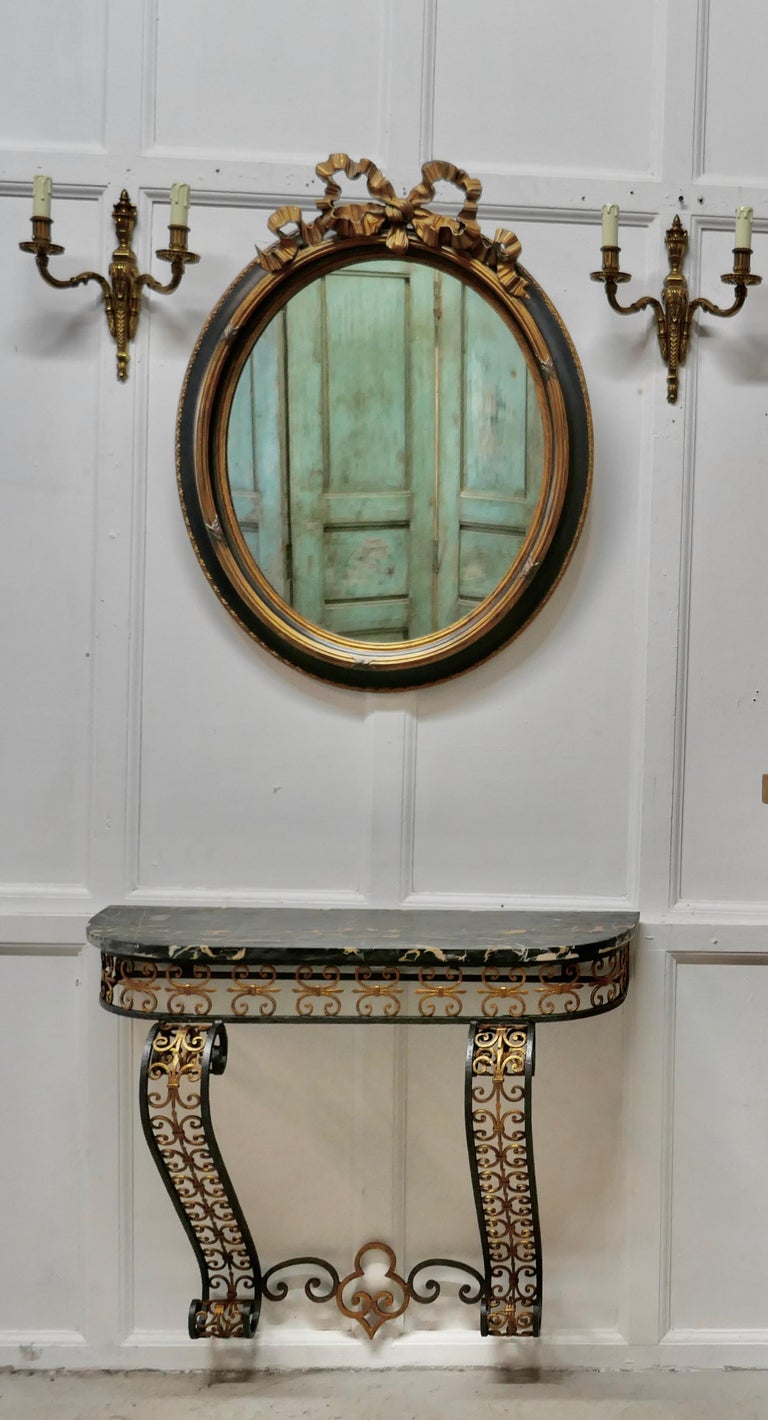 French iron and marble console table with matching mirror

This is an unusual set the table is wall fixed so can be set to your chosen height, the base of the table is made in decorative wrought iron painted in black and gold, it has a black