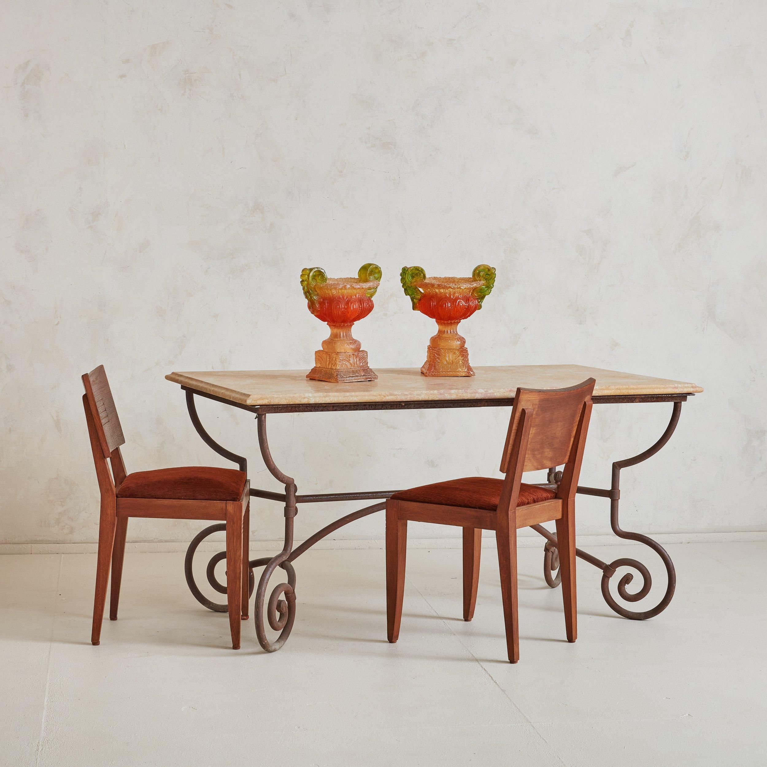 A gorgeous and classic dining table or occasional table from the South of France. The wrought iron base is one of our favorite materials and this table features a beatifully forged curved base. The marble table top we designed specifically to pair