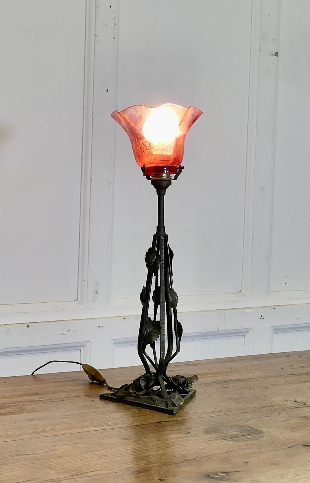 Lampe française en fer et en tôle avec abat-jour en verre à feuilles d'or et rubis

Il s'agit d'une pièce très attrayante, la lampe a une colonne centrale triangulaire décorée de roses et de feuilles qui soutient un joli abat-jour en verre rubis,