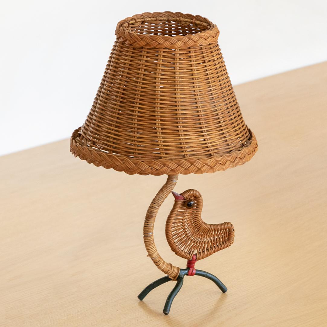 Unique small vintage iron and wicker table lamp from France, 1960's. Black iron curved stem with wrapped wicker detail and three leg iron base. Cute small wicker bird as whimsical detail on base. Original wicker shade and newly rewired. 