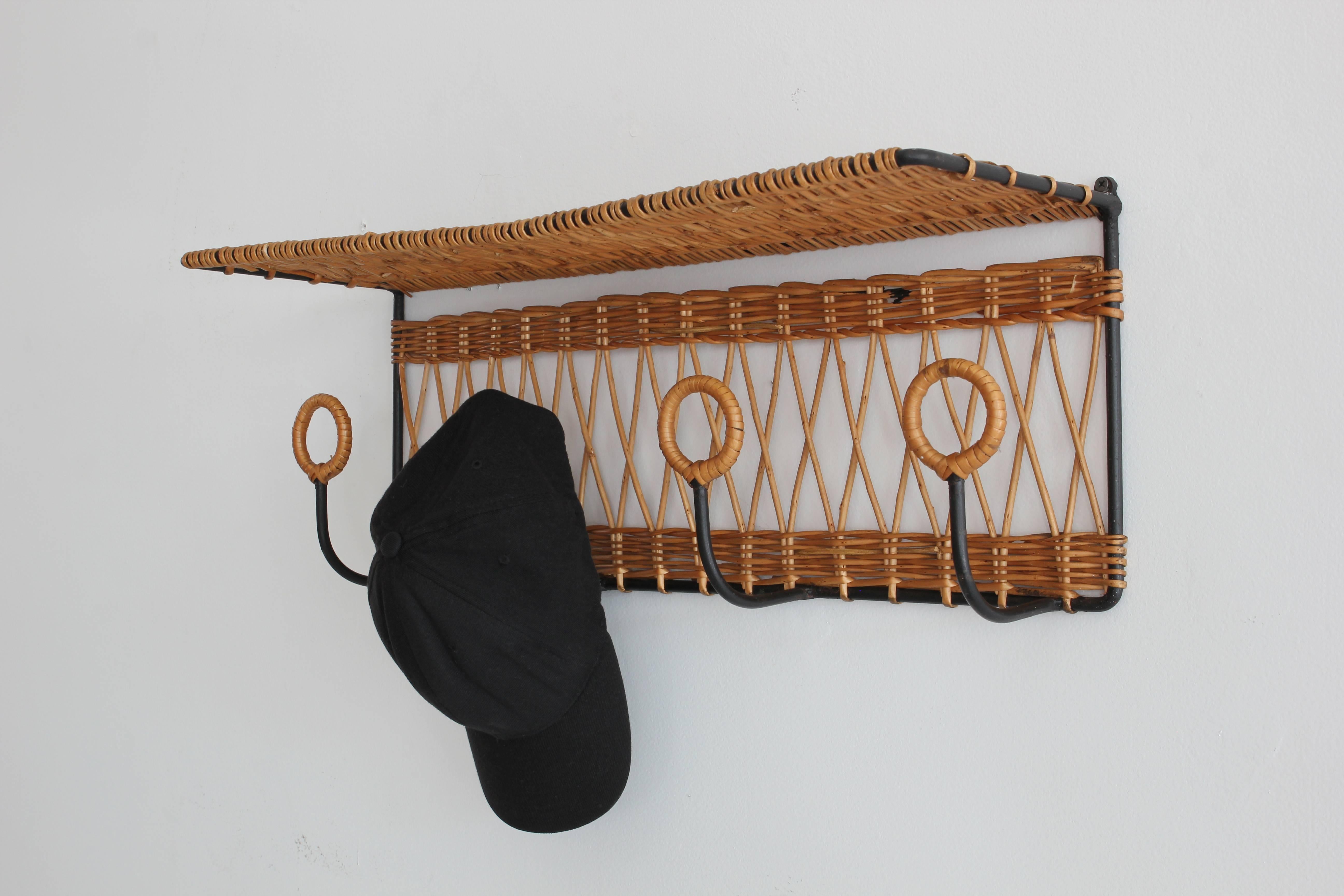 Beautiful iron shelf and set of four hooks for coats, hats, or bags in classic Adnet silhouette wrapped in wicker.