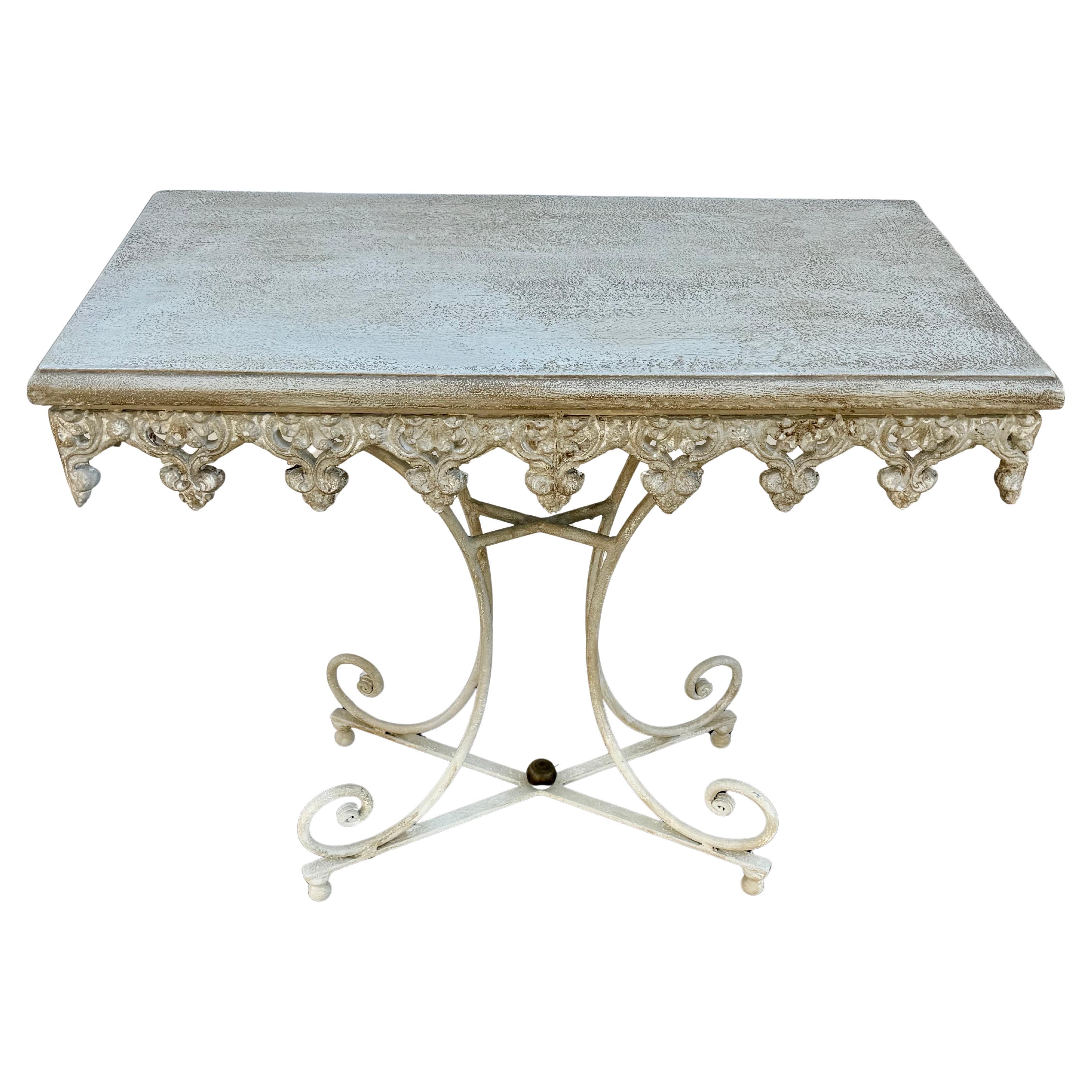 Fabriquée en France, la table de travail en fer présente un tablier festonné avec un travail de métal complexe, de beaux pieds à volutes et un épi de faîtage décoratif en laiton poli. Cette table de pâtisserie française ou table à vin ajoutera la